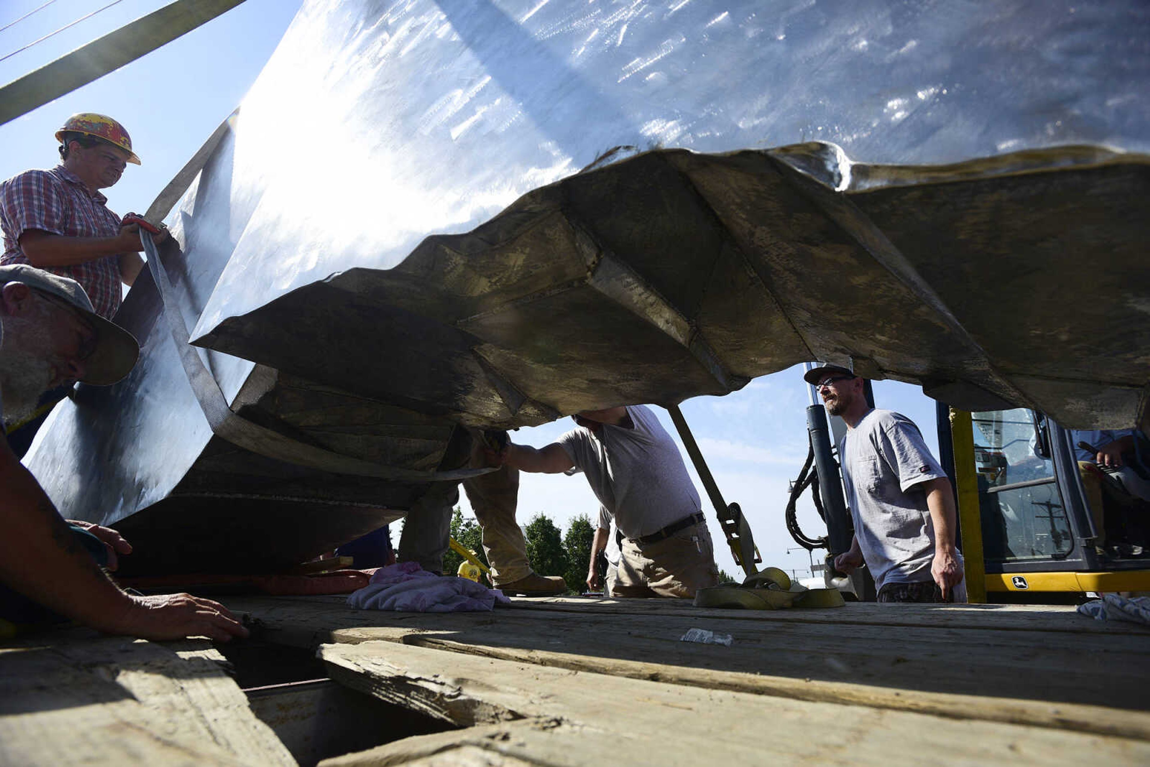 Chris Wubbena watches as Cape Girardeau Parks and Recreation employees secure Wubbena's 14-foot sculpture to lift for installation in the Fountain Street roundabout on Monday, July 24, 2017, near the River Campus in Cape Girardeau.