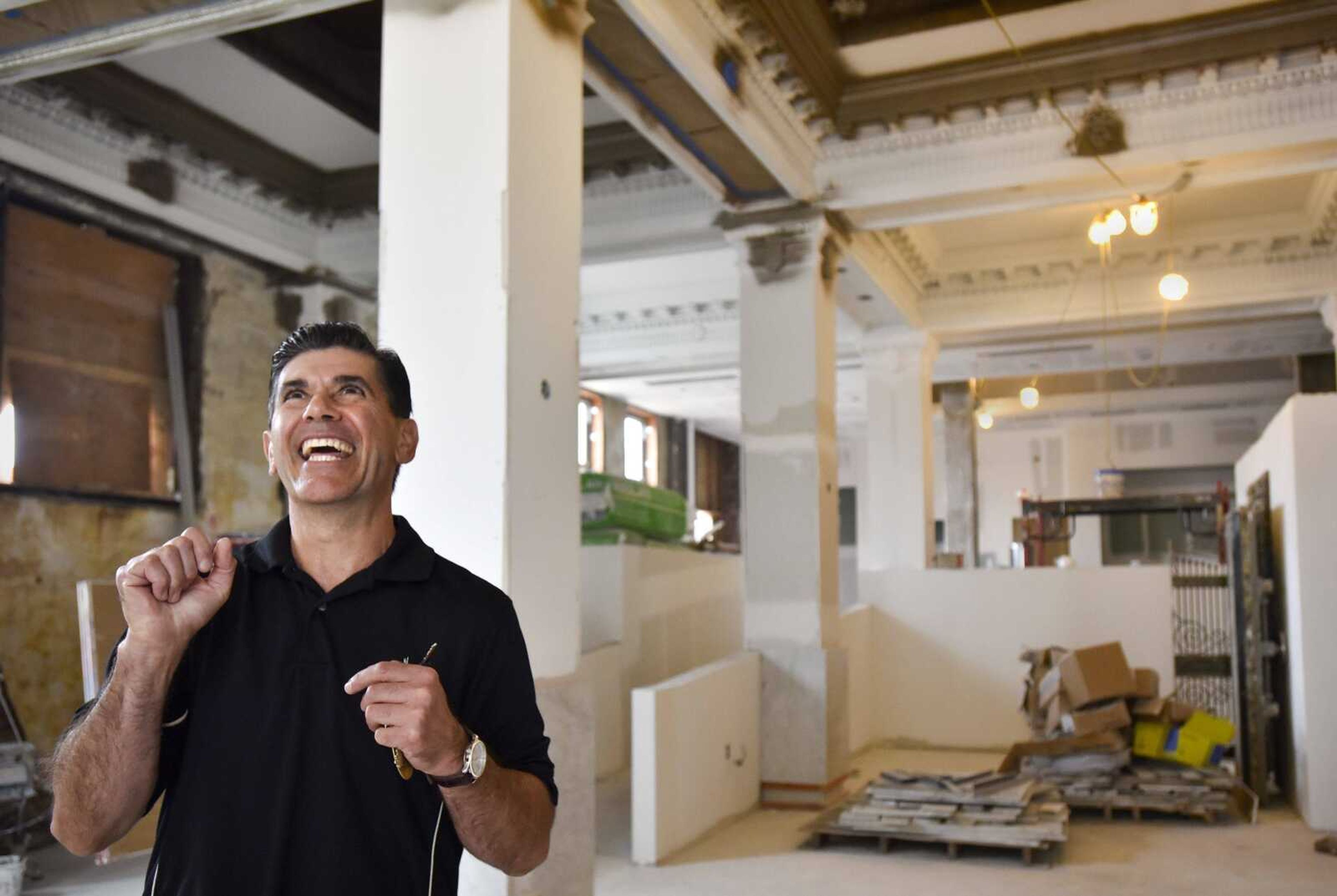 Andre Borrelli points out ornamental designs he restored in the lobby of the former H-H Building as he gives a tour Wednesday in Cape Girardeau.