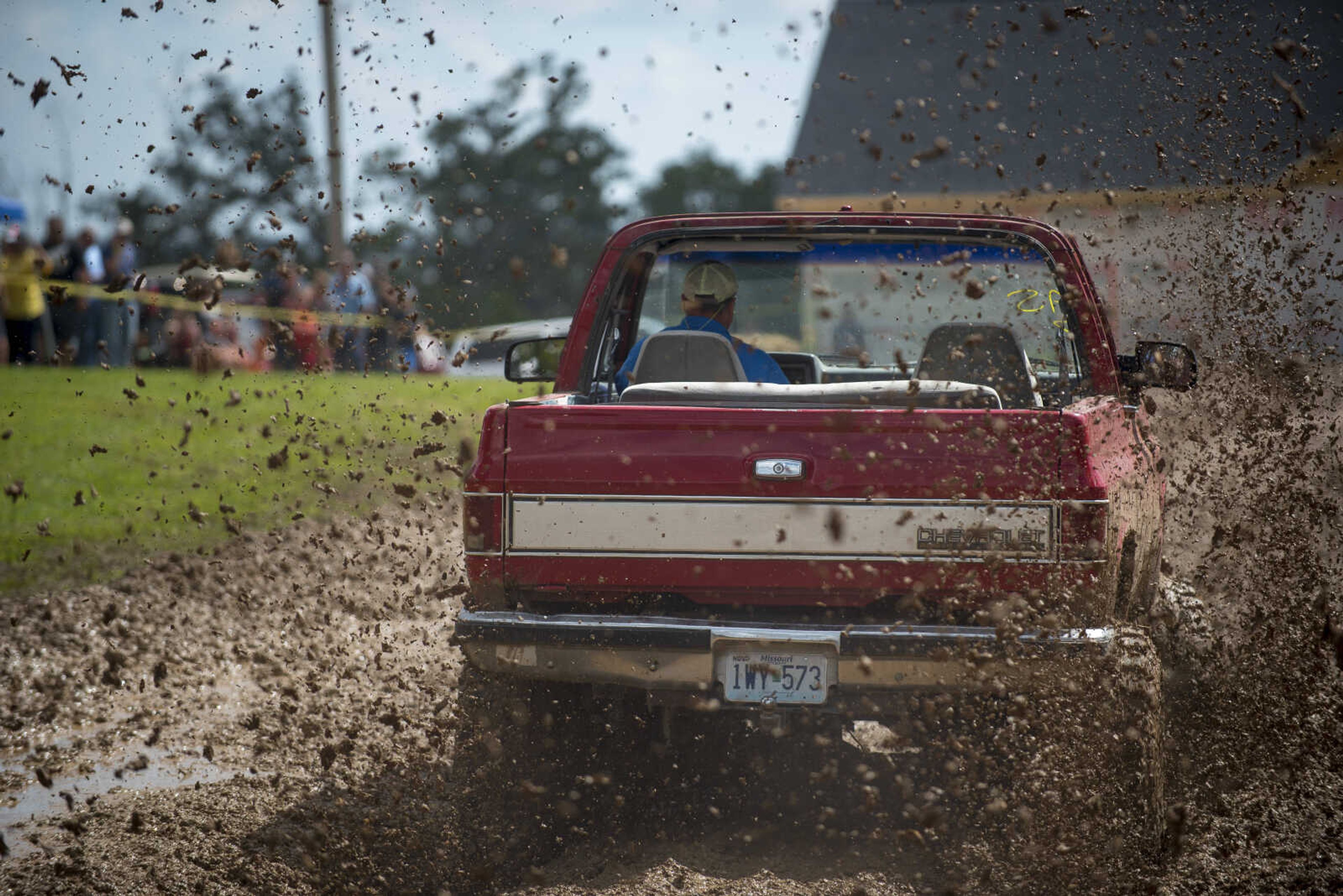 A truck flings mud as it heads down the racetrack during Benton Neighbor Days Saturday, September 1, 2018.