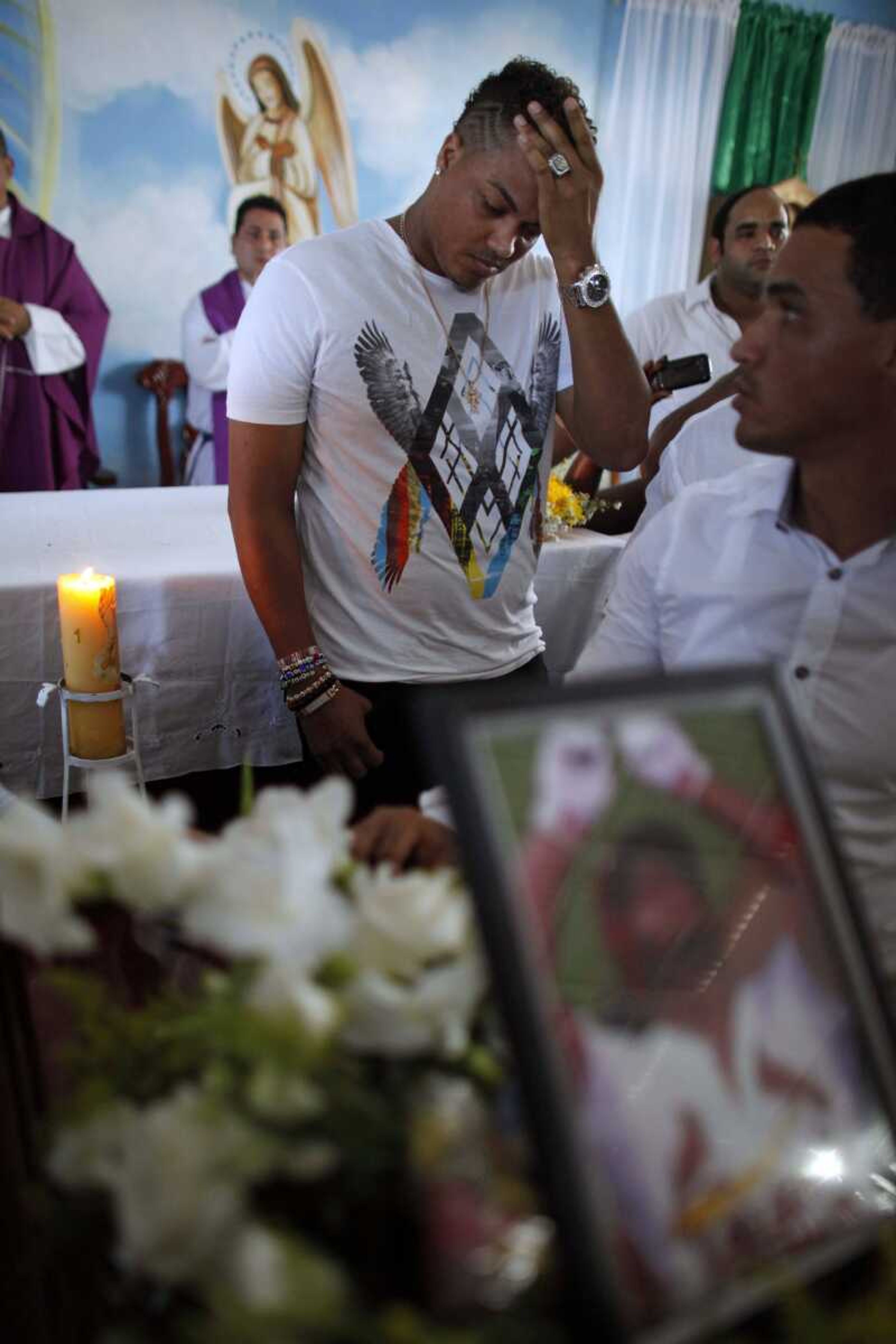 Cincinnati Reds pitcher Alfredo Simon attends the funeral of St. Louis Cardinals outfielder Oscar Taveras last month in Sosua, Dominican Republic. Simon was accused in 2011 of fatally shooting a man in the Dominican Republic, but he maintained it was an accident and the charges were dropped. There are plenty of players who travel back and forth with no controversy, but the handful of situations worry U.S. teams that invest millions of dollars in developing players. (Ricardo Arduengo ~ Associated Press)