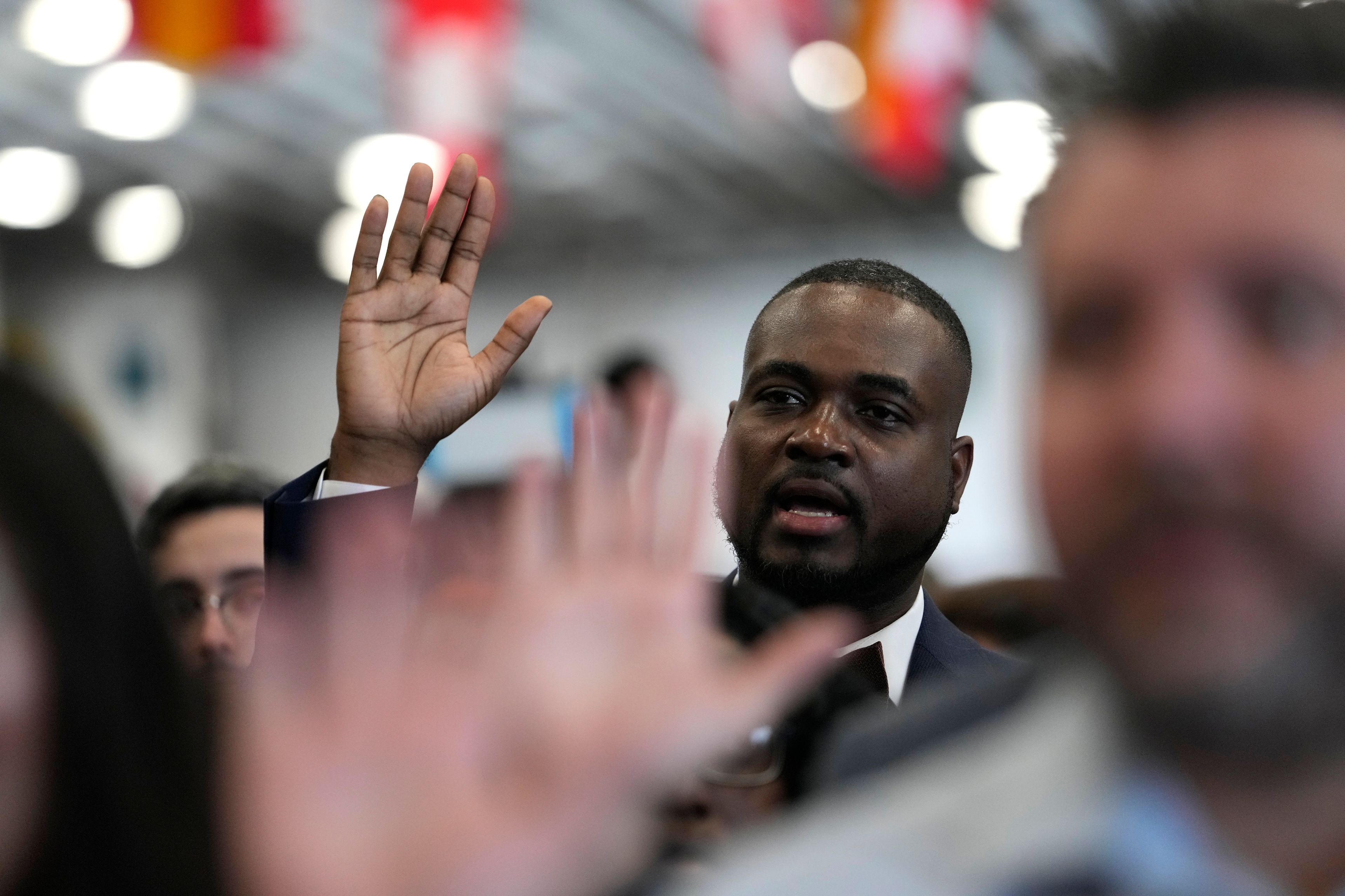 FILE - Smith Fisnord of Haiti raises his right hand as the takes the Oath of Allegiance to the United States of America during a naturalization ceremony aboard the USS Bataan during Fleet Week Miami at PortMiami, Tuesday, May 7, 2024, in Miami. (AP Photo/Lynne Sladky, File)