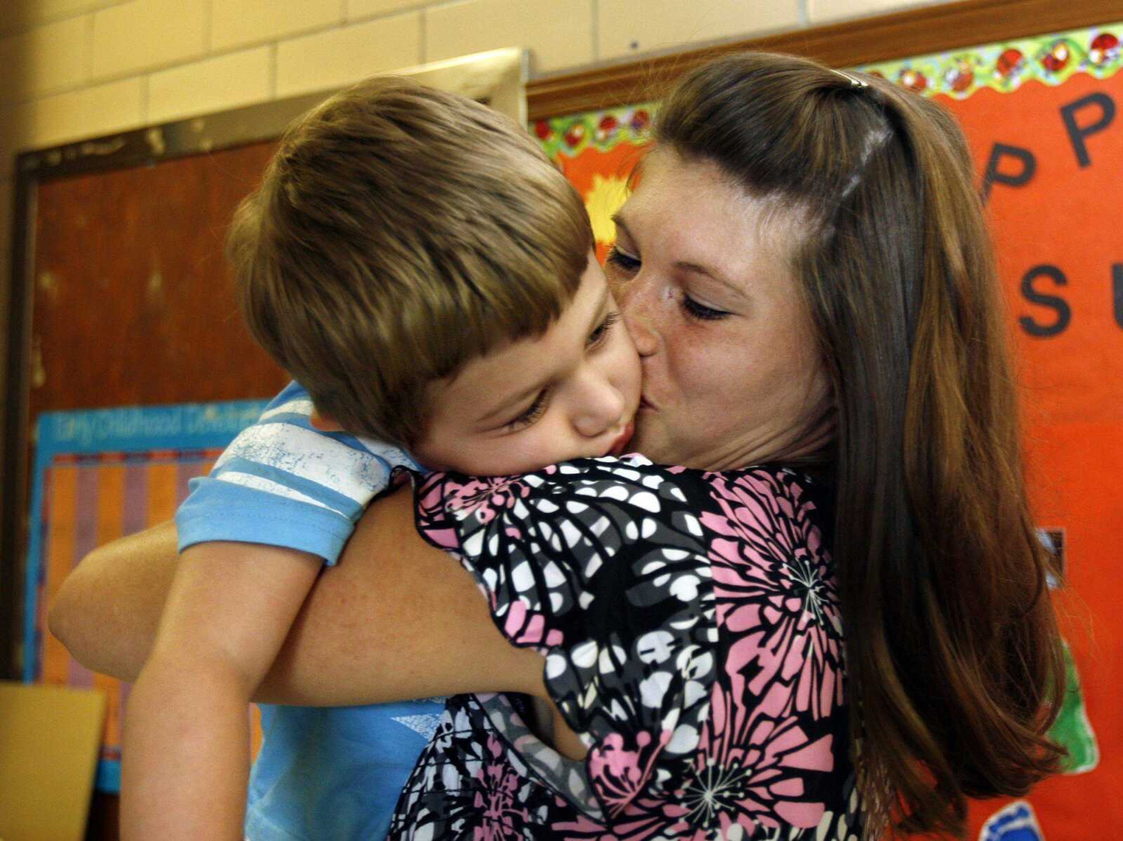 Whitney McFall of Oak Ridge wakes up her son, Gavin, 3, by kissing him Friday after a teaching session at Oak Ridge Elementary School. (Elizabeth Dodd)