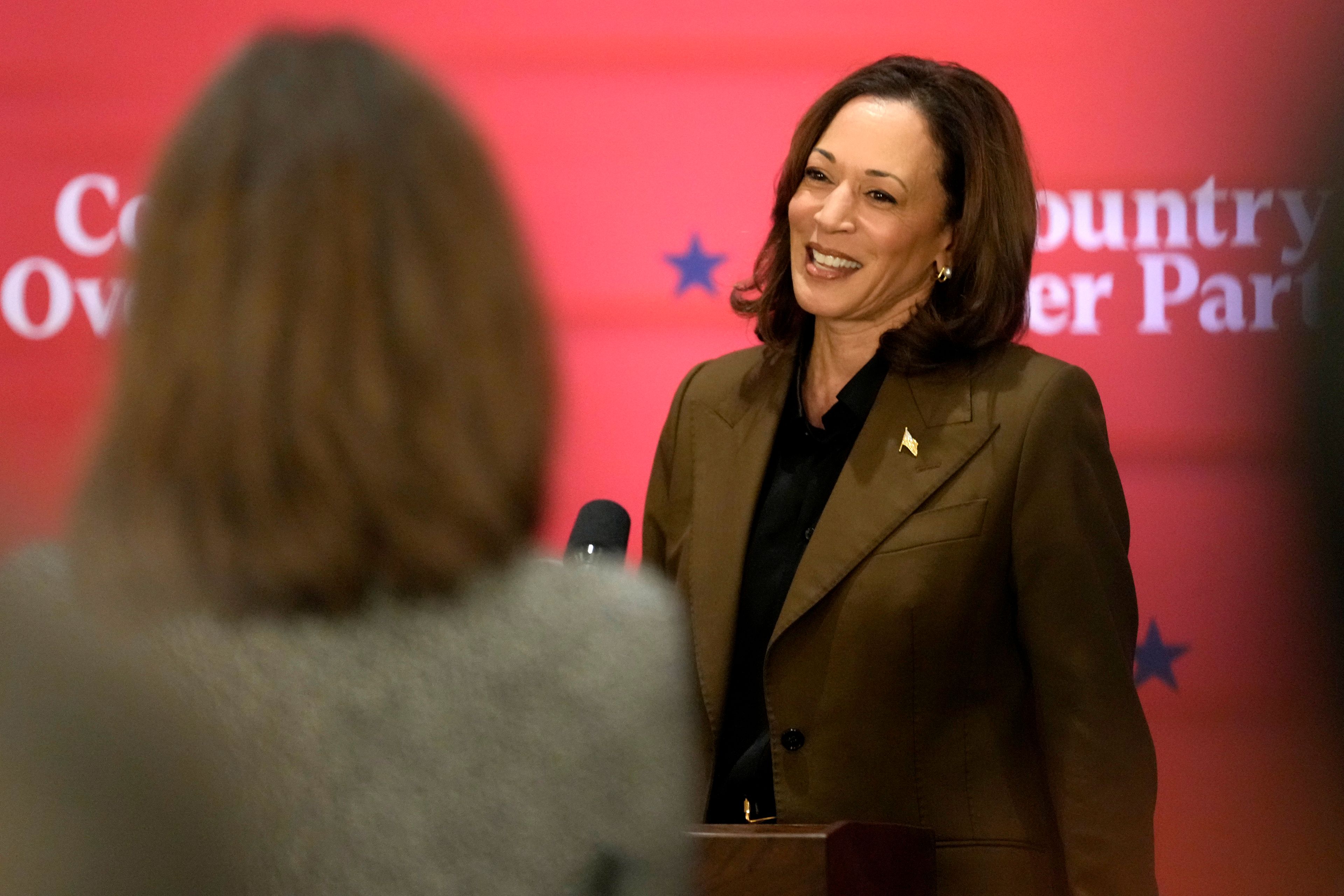 Democratic presidential nominee Vice President Kamala Harris speaks as an attendee looks on at a campaign event Friday, Oct. 11, 2024, at the Grayhawk Golf Club in Scottsdale, Ariz. (AP Photo/Ross D. Franklin)