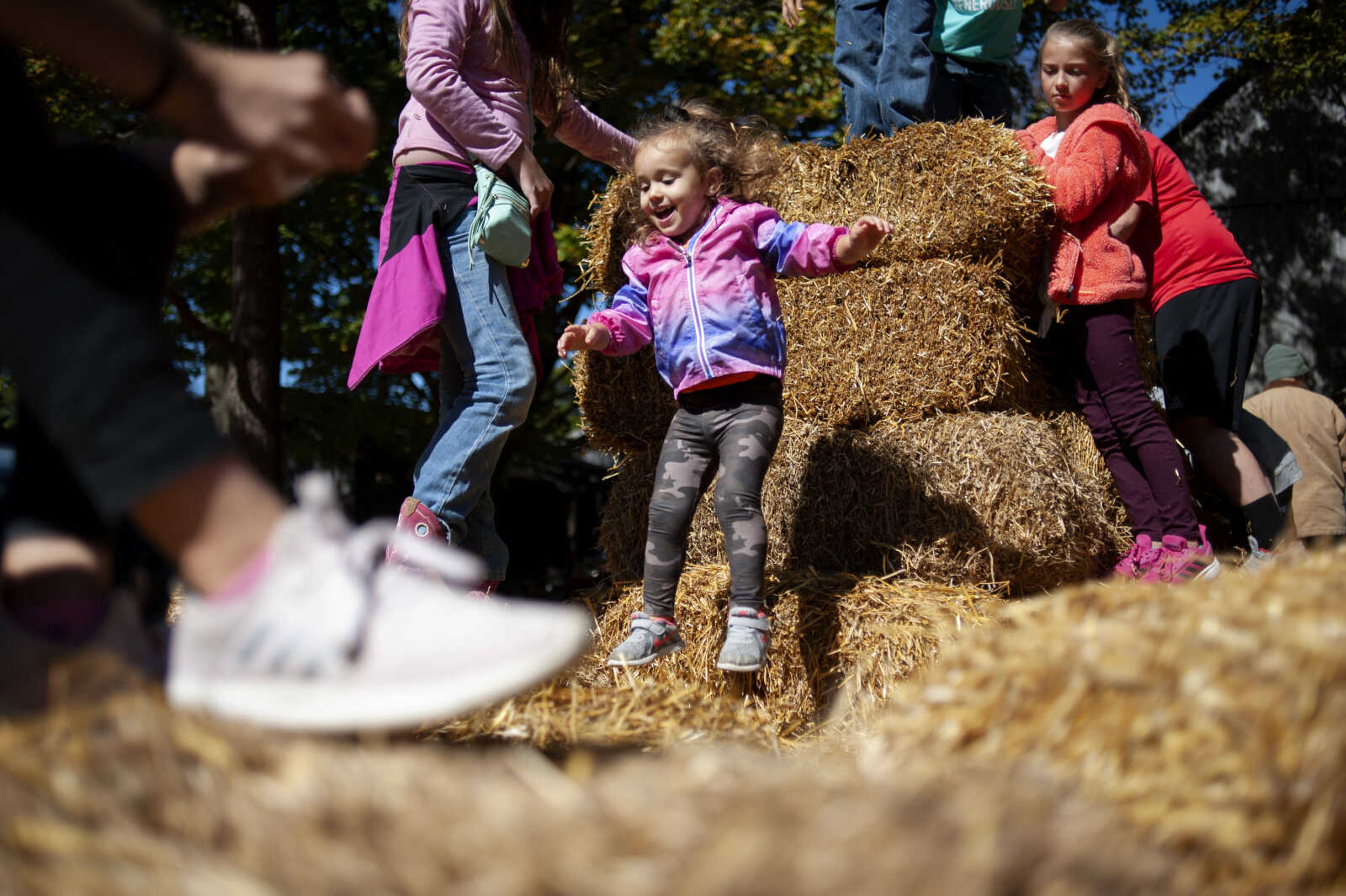 Maggie Rice, 2, of Perryville, Missouri, jumps into hay at the Saxon Lutheran Memorial's 39th annual Fall Festival on Saturday, Oct. 12, 2019, in Frohna, Missouri.&nbsp;