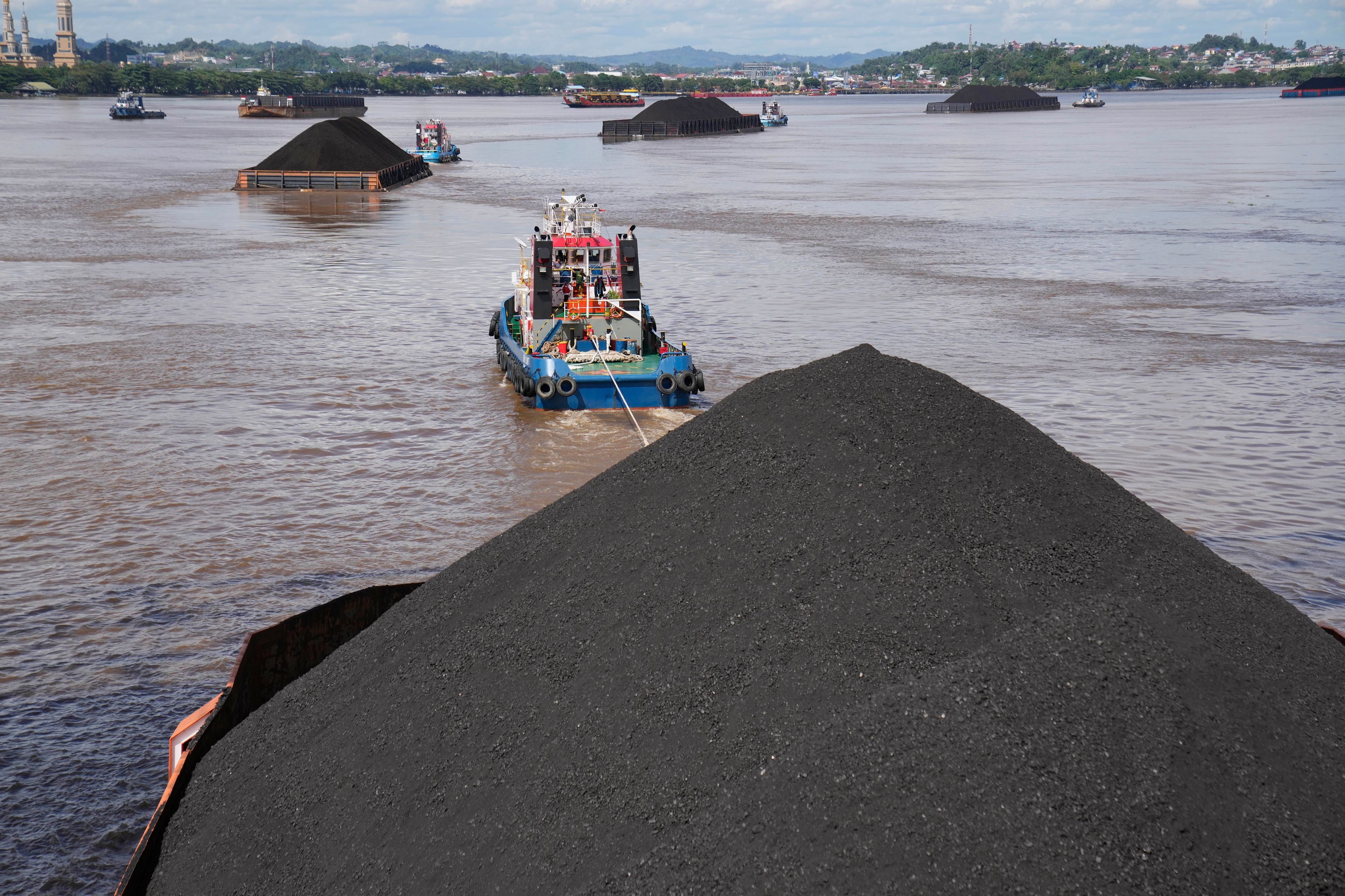 FILE - Tug boats pull barges fully loaded with coal on the Mahakam River in Samarinda, East Kalimantan, Indonesia, on Dec. 19, 2022. (AP Photo/Dita Alangkara, File)