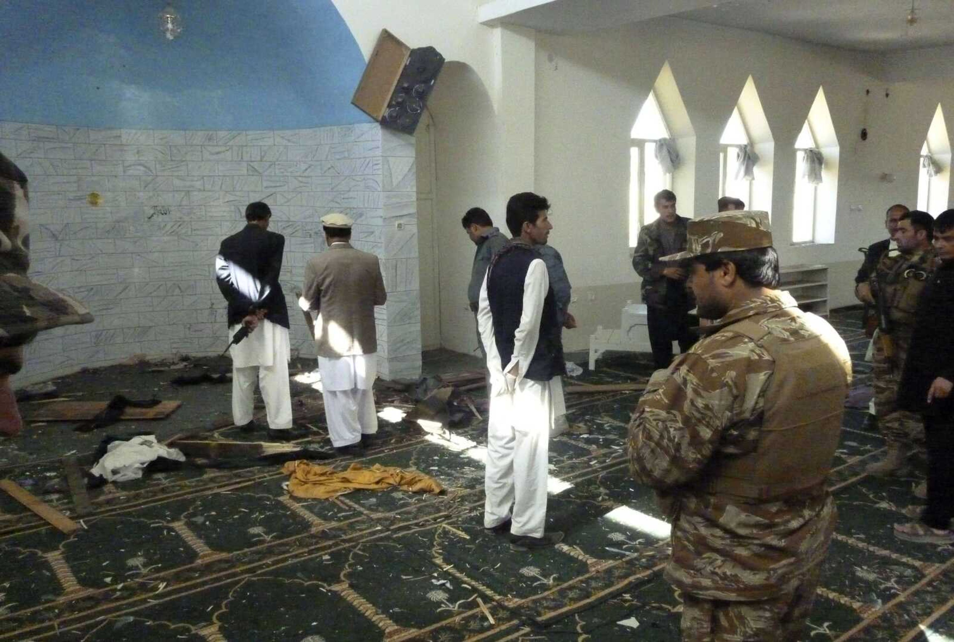 Afghan police and officials examine the mosque in Puli Alam, Logar Province, Afghanistan, where a bomb hidden in the base of a microphone killed Afghan Governor Arsallah Jamal on Tuesday. No one immediately claimed responsibility for the attack, but the Taliban have been targeting Afghan officials, military and NATO troops as part of a campaign to retake territory as international troops draw down ahead of a full pullout at the end of 2014. (Ahsanullah Majuze ~ Associated Press)