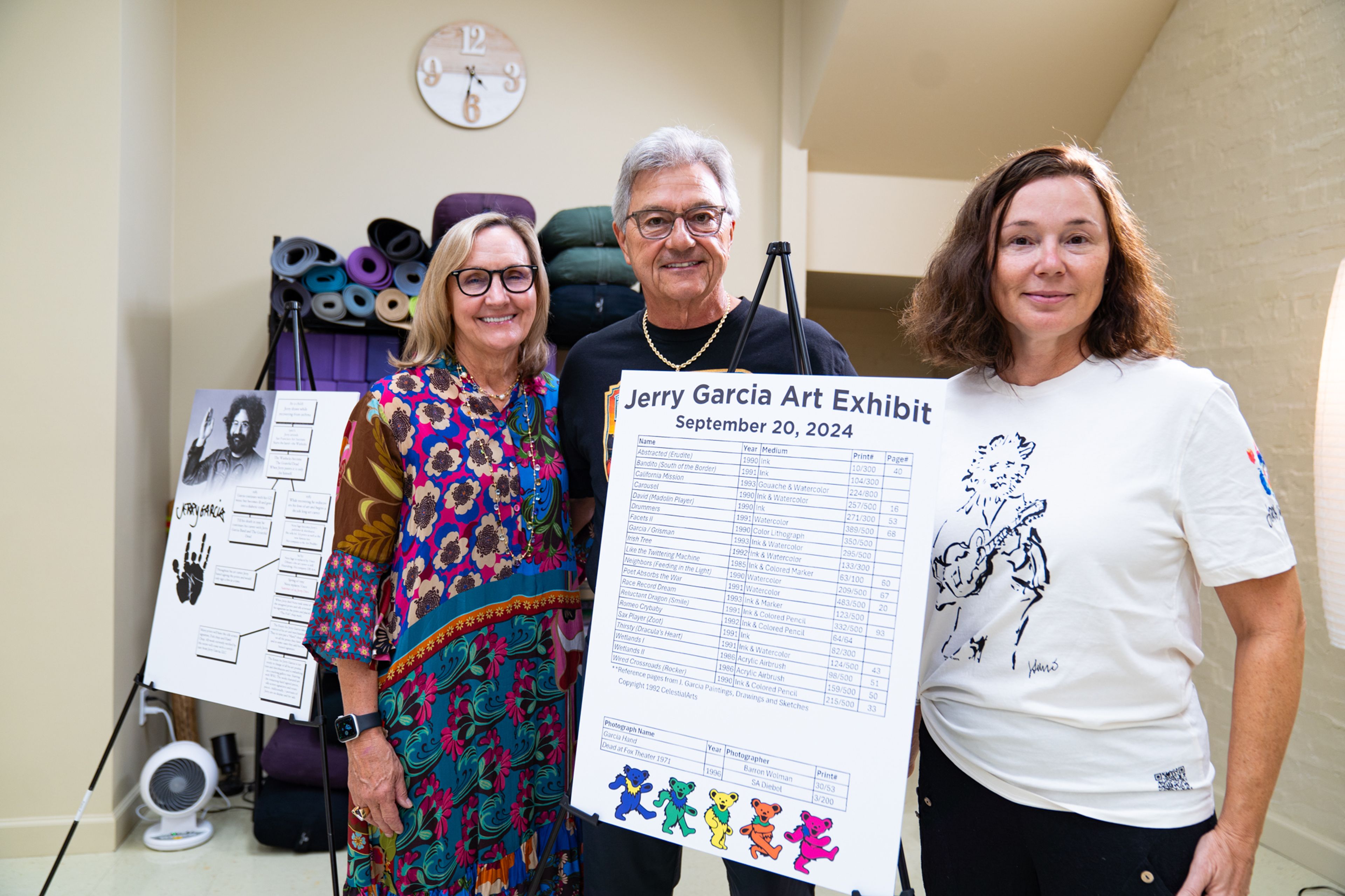 (Left) Kathy Holloway, Keith Holloway 
 and owner of Yoga East Healing Arts Studio stands by a list of pieces in the exhibit on Friday, Sept. 20 at Yoga East Healing Arts Studio. Holloway showed his collection of Jerry Garcia art to raise funds for the Jack Finney Foundation.