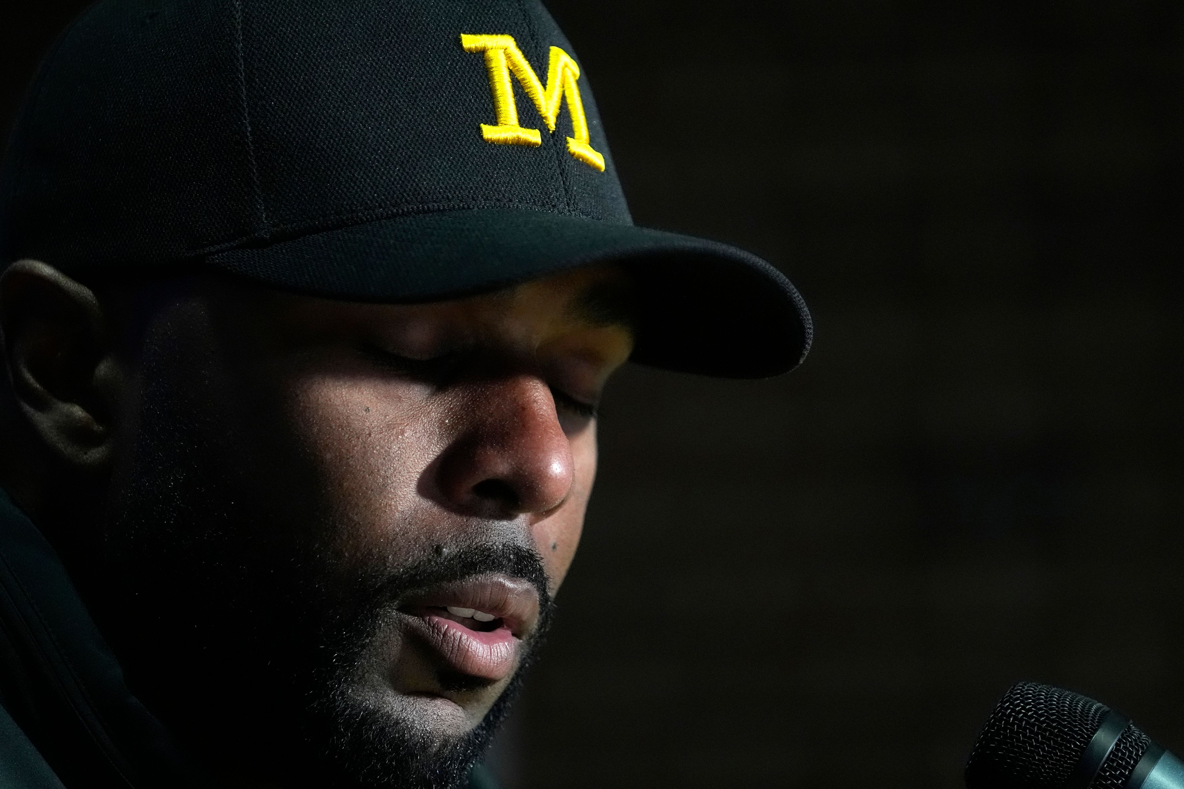 Michigan head coach Sherrone Moore puts his head down in a news conference after his team's 21-7 loss to Illinois in an NCAA college football game Saturday, Oct. 19, 2024, in Champaign, Ill. (AP Photo/Charles Rex Arbogast)