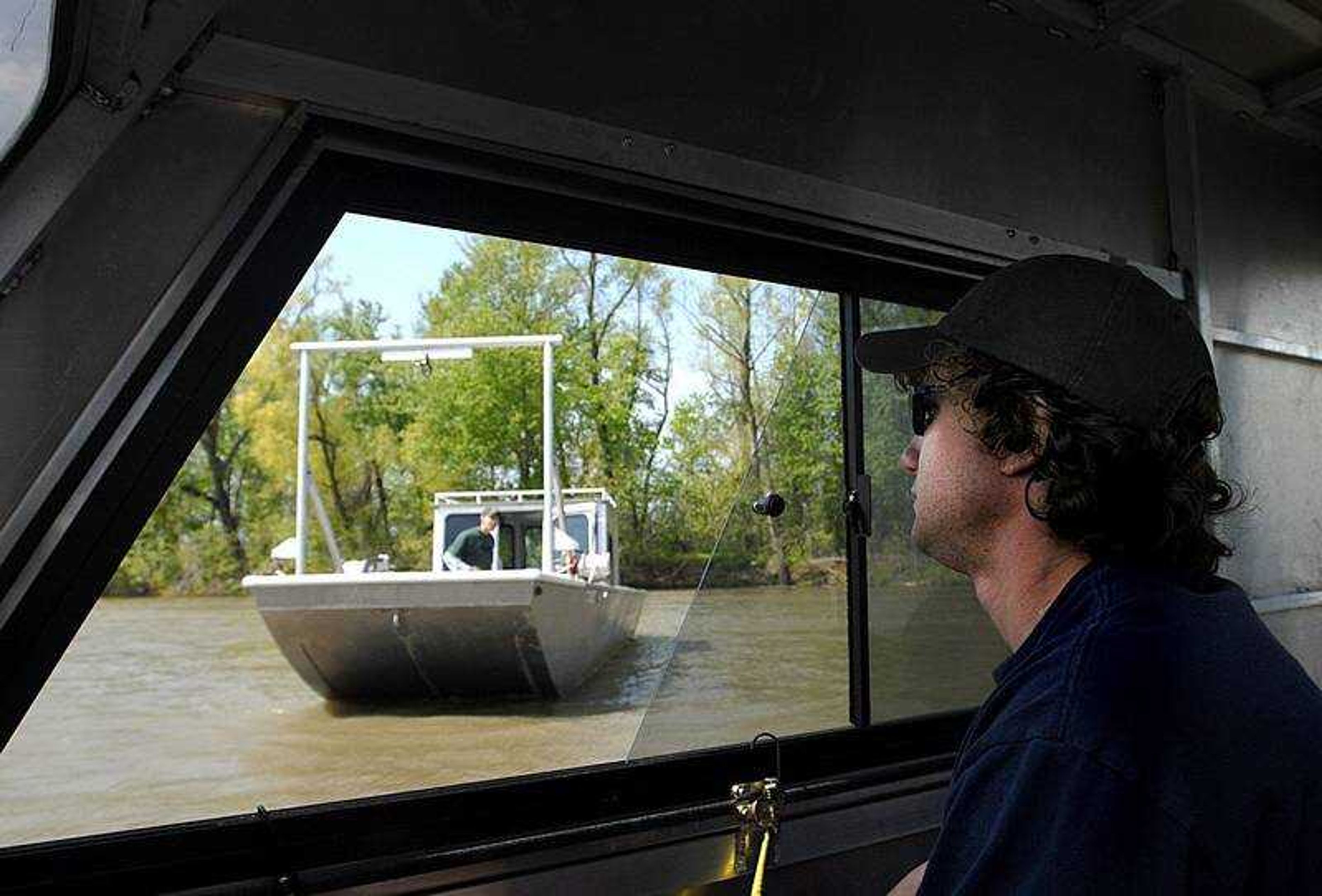 AARON EISENHAUER ~ aeisenhauer@semissourian.com
Tyler Stearns of the Missouri Department of Conservation steers one of the boats used to track pallid sturgeon in the Mississippi as another of the team's boats passes by on Wednesday, April 30, 2008.