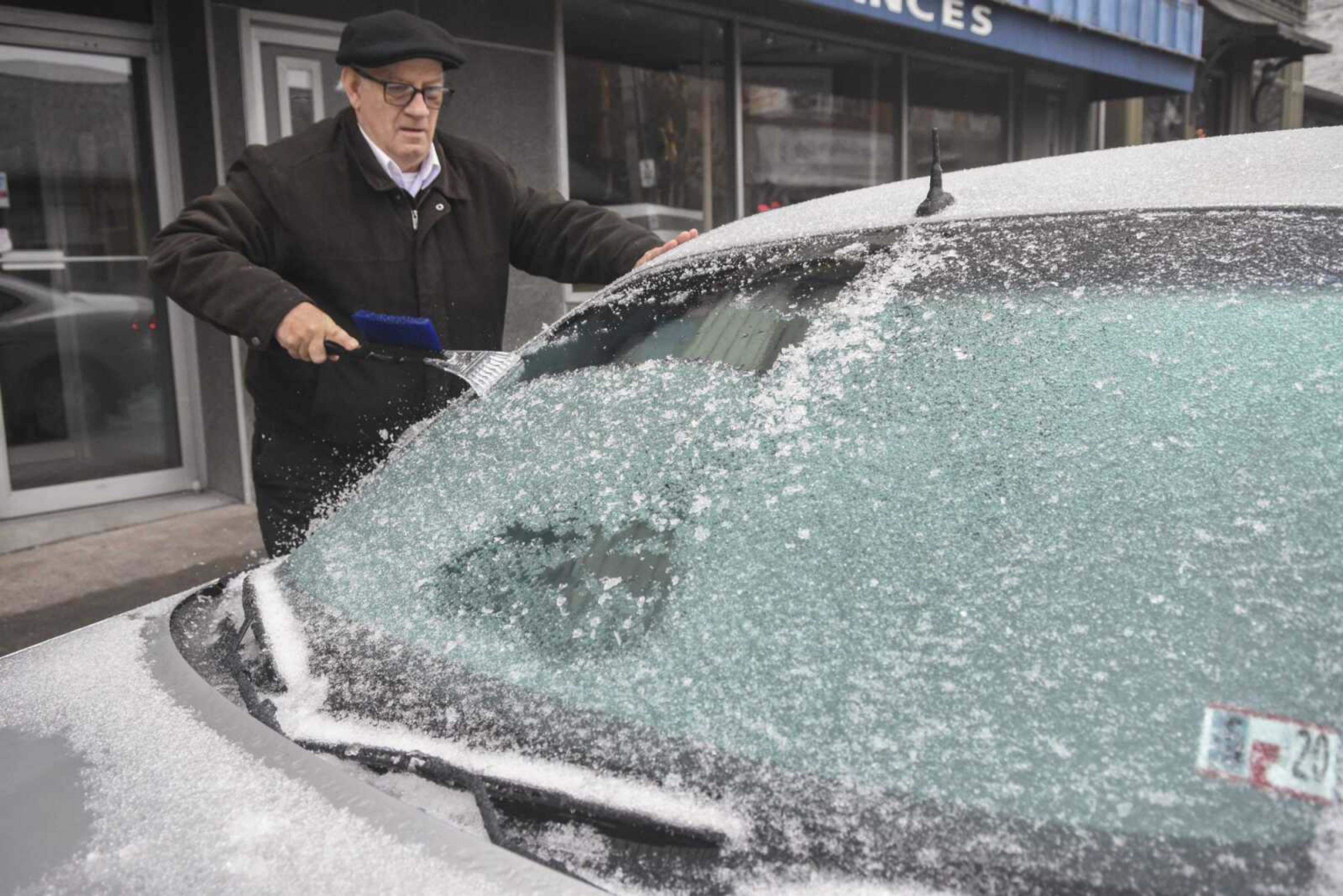 Paul Ciotti, of Minersville, Pennsylvania, scrapes ice off of his car windshield parked along Sunbury Street on Sunday in Minersville.