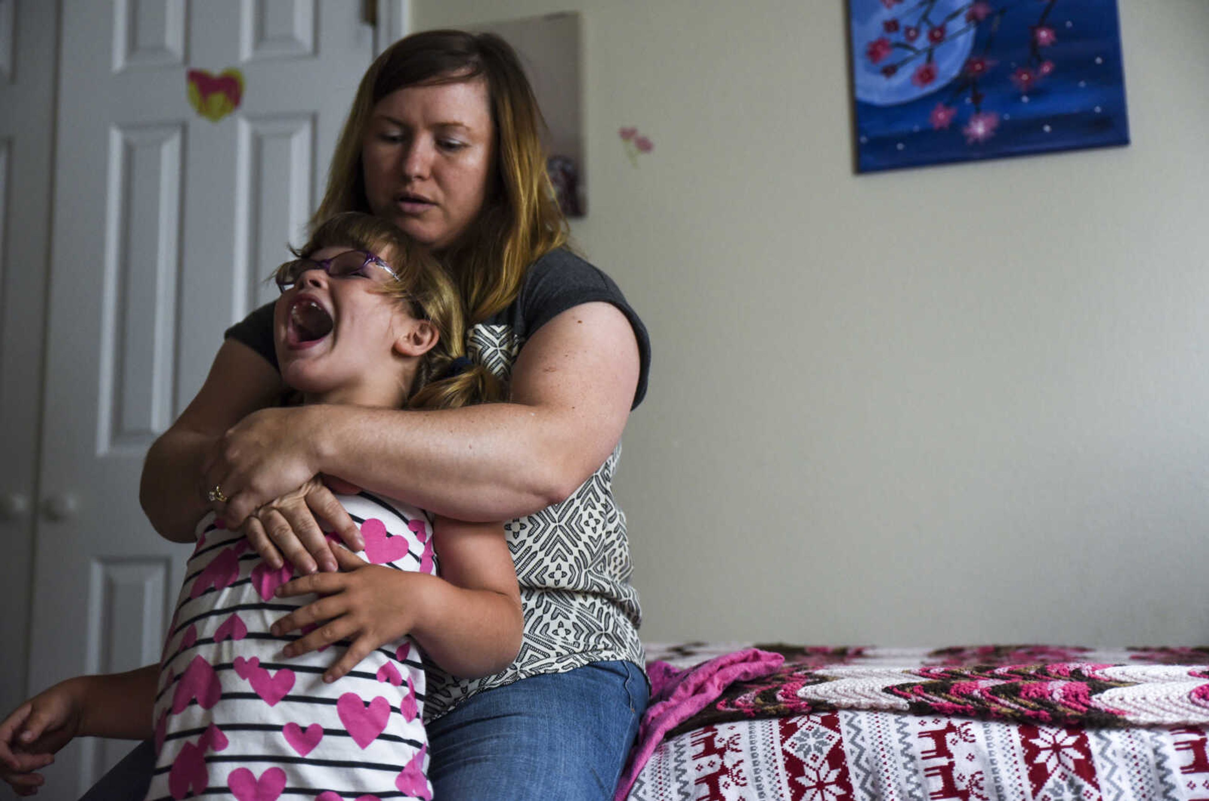 Lindyn Davenport laughs while her mother Meredith Davenport helps her daughter to relax in her bedroom Sunday, June 3, 2018 in Sedgewickville.