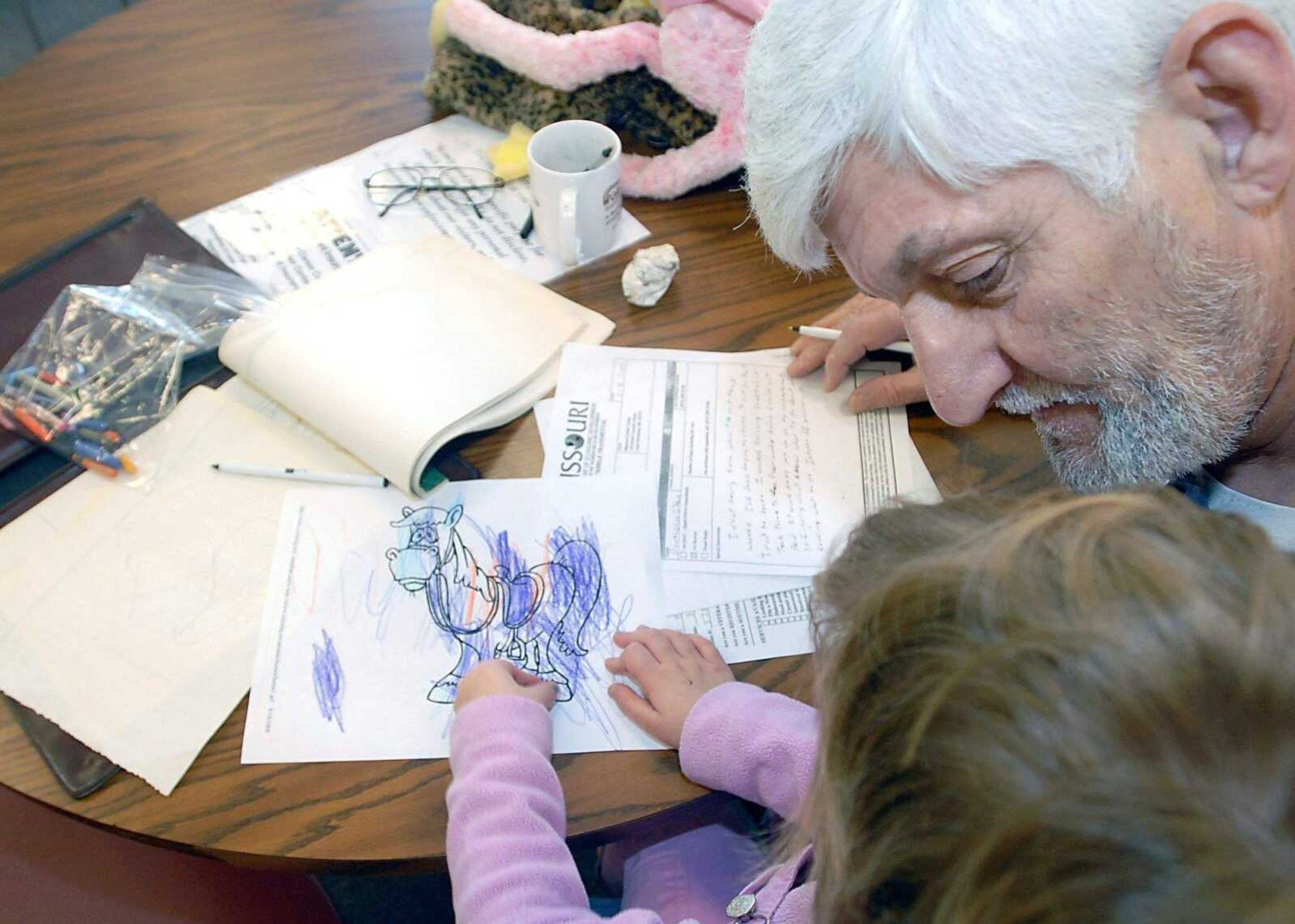 KIT DOYLE ~ kdoyle@semissourian.com<br>Donald Gibbons takes a break from filling out paperwork Friday at the Cape Girardeau Career Center to talk with his granddaughter, Abraina, as she colors. Gibbons, a construction worker for 30 years, said he has never had as much difficulty finding work as he currently is.