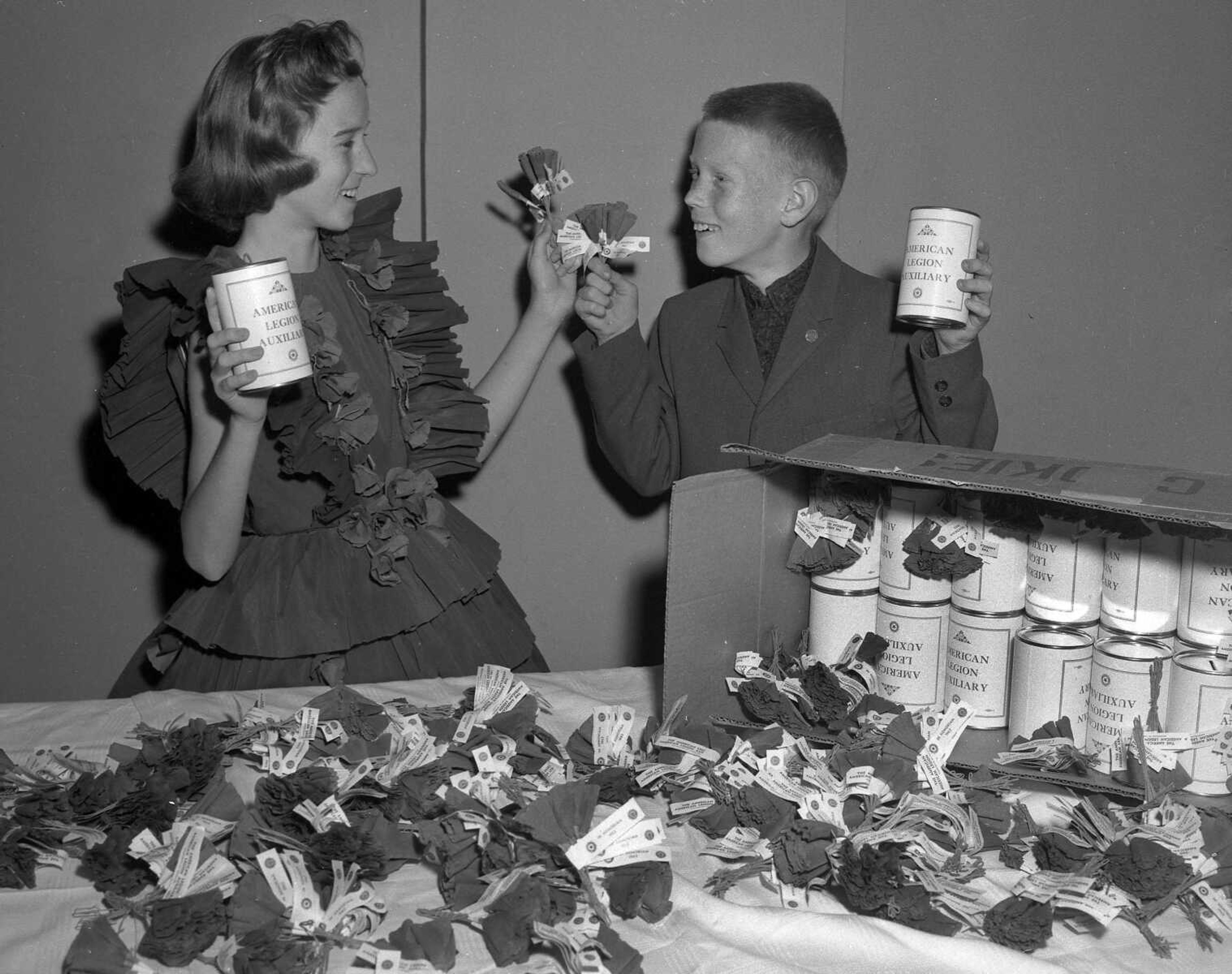 Two unidentified youngsters prepared for the American Legion Auxiliary's annual sale of poppies. Van and Mary White wrote: "The girl in the picture looks like Rita Heimbaugh." Bill Stone wrote: "In this photo these are my first cousins, Rita Heimbaugh Weber and Walter John Heimbaugh. For years their late mother, Alberta Heimbaugh, was involved in the Poppy Day for the American Legion."