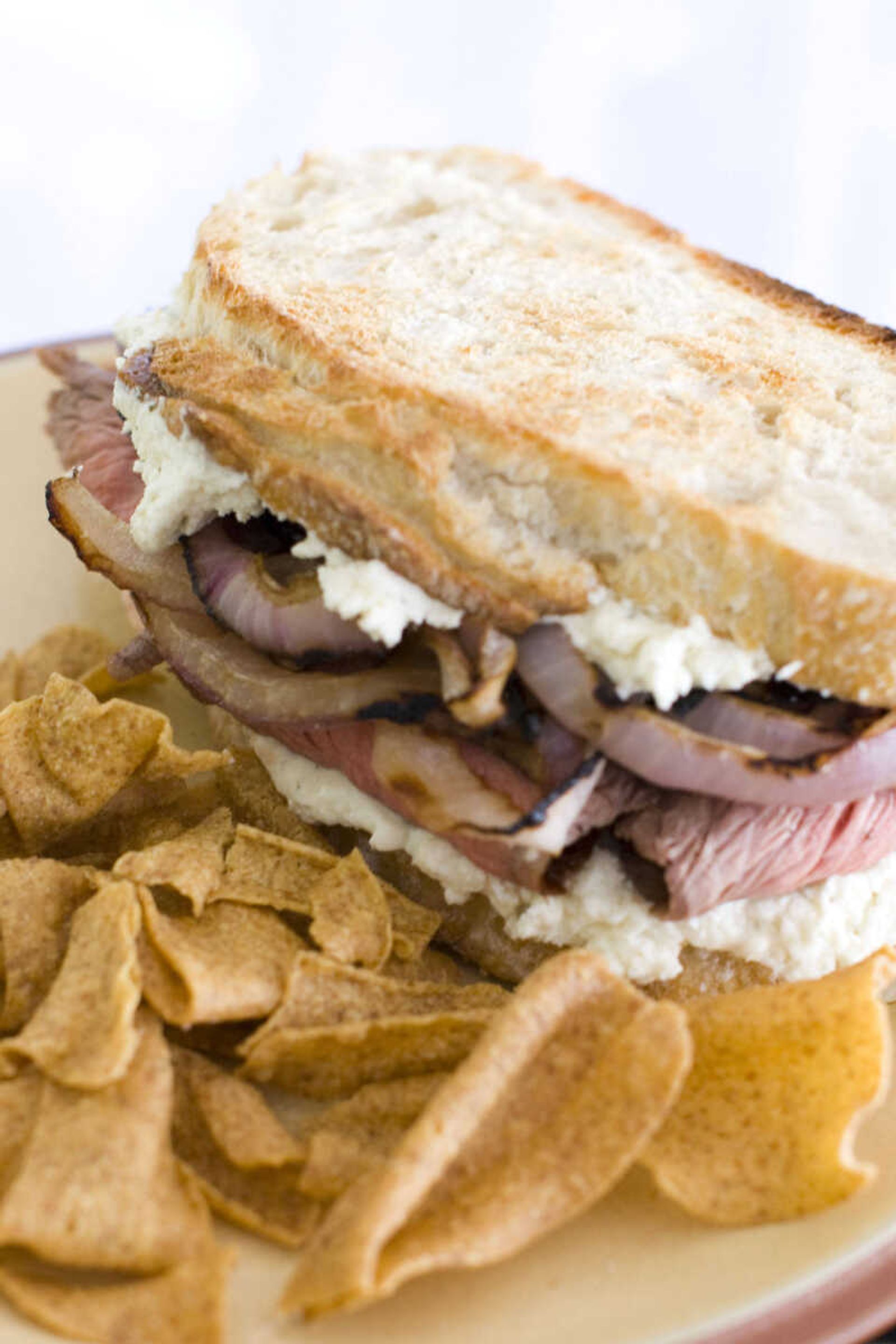 A sandwich made of flank steak with slices of red onion marinated in  Guinness lager and Boursin cheese, is shown. (AP Photo/Matthew Mead)