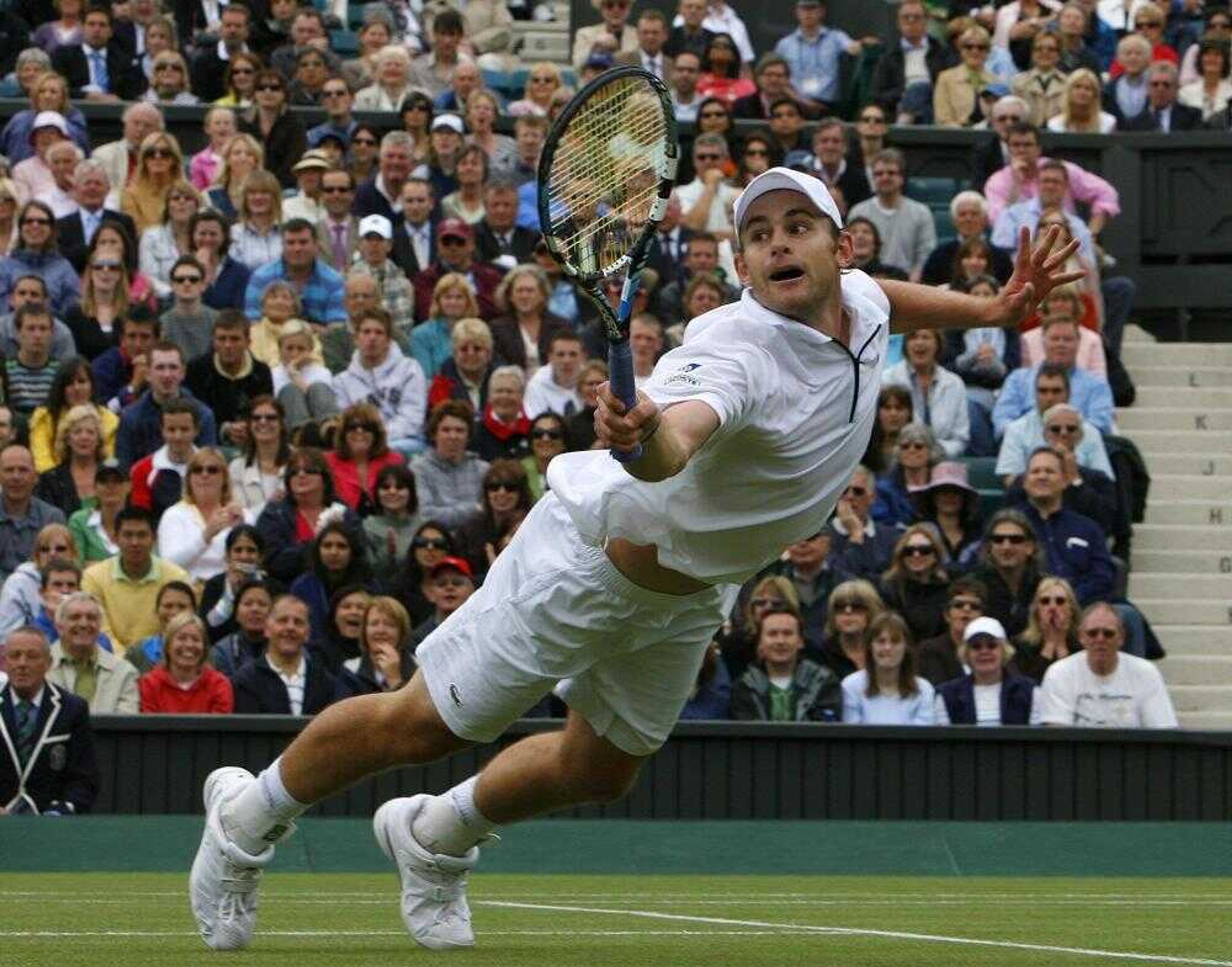 Andy Roddick dove to return the ball to Danai Udomchoke during their match Wednesday at Wimbledon. (Anja Niedringhaus ~ Associated Press)