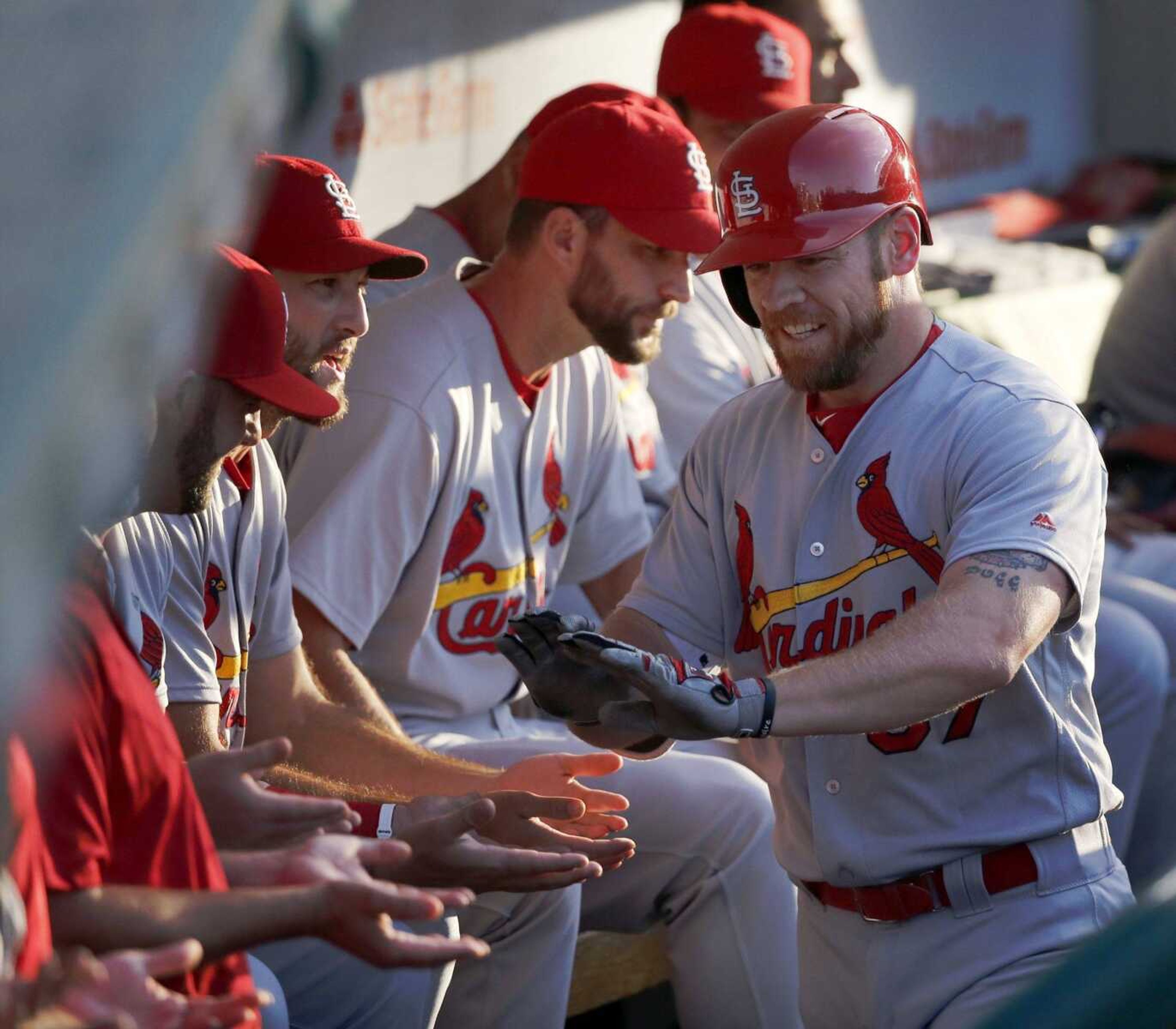 The Cardinals' Brandon Moss celebrates in the dugout after his home run off Cubs starting pitcher John Lackey during the second inning Monday in Chicago. The Cardinals won 3-2.