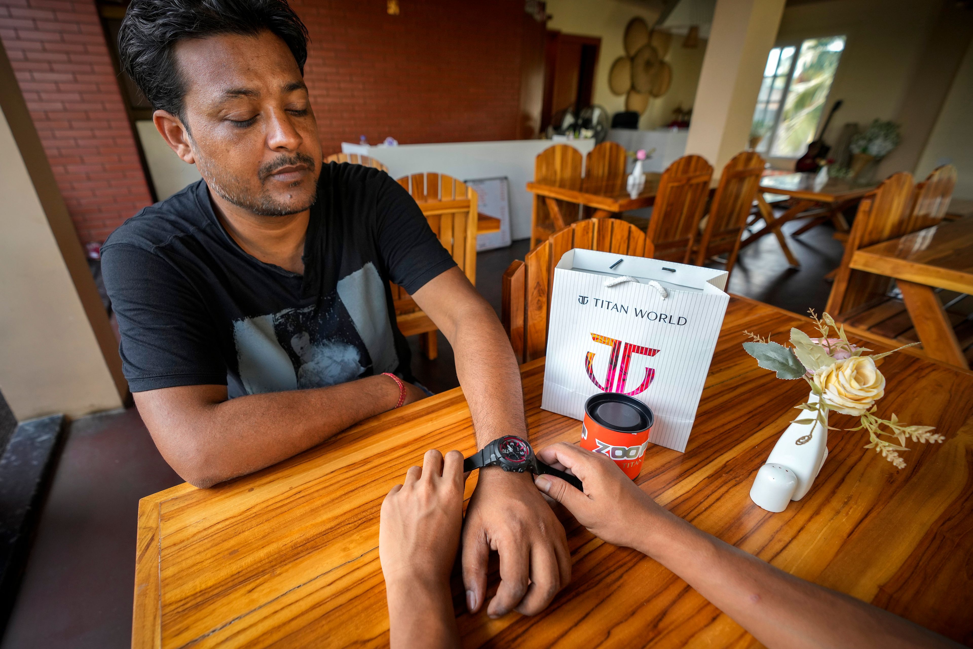 A man gifts a Tata made Titan sports watch to his friend in Guwahati, India, Thursday, Oct. 10, 2024. (AP Photo/Anupam Nath)