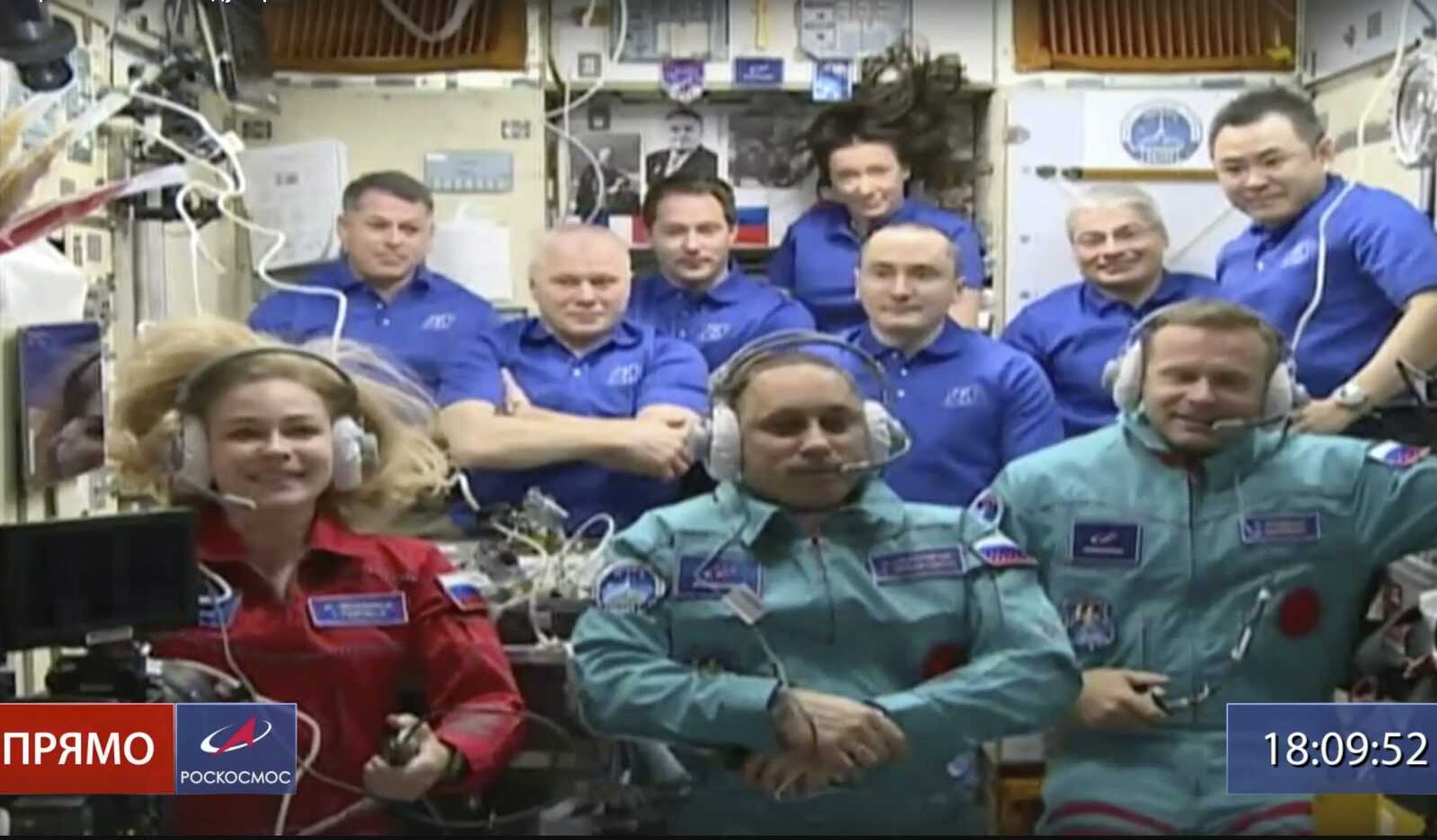 In this photo taken from video footage, actress Yulia Peresild, left, film director Klim Shipenko, right, and cosmonaut Anton Shkaplerov sit in the first row among other participants of the mission Tuesday in the International Space Station.