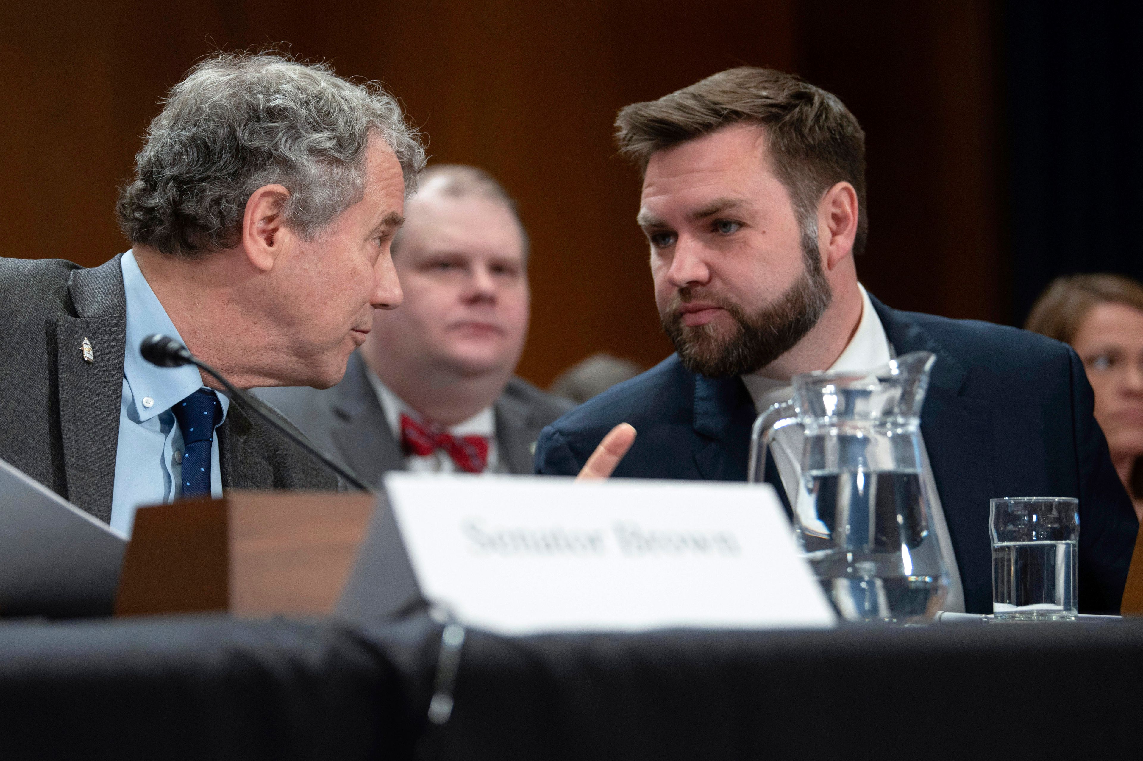 FILE - Sen. JD Vance, R-Ohio, right, speaks with Sen. Sherrod Brown, D-Ohio, before testifying at a hearing, March 9, 2023, in Washington. (AP Photo/Kevin Wolf, File)