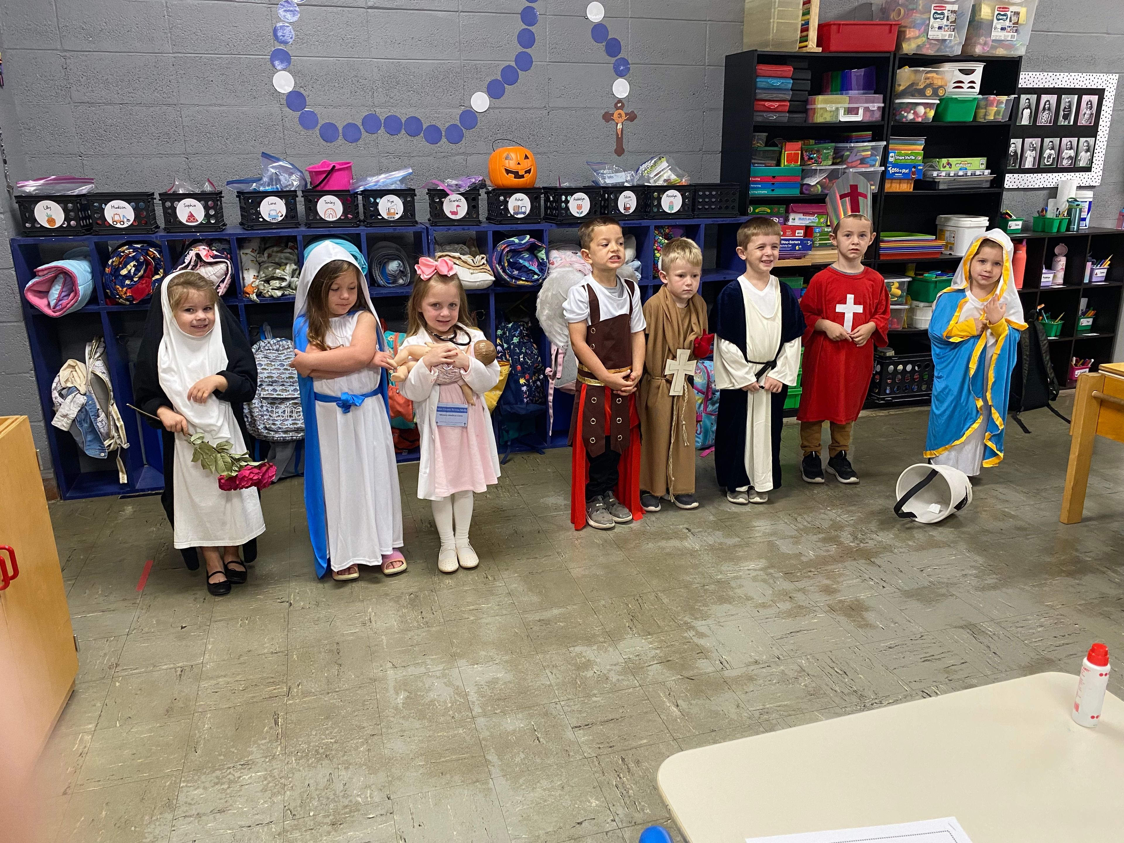 PK-4 Saints were St. Rose of Lima (Lilly Seyer), the Blessed Virgin Mary (Sophia Enderle), St. Gianna (Tenley Glastetter), St. Michael the Archangel (Hudson Seyer), St. Francis of Assisi (Asher Floyd), St. Paul (Lane Overfield), St. George (Tolson VanGennip), and another Blessed Virgin Mary (Scarlett Crumley).