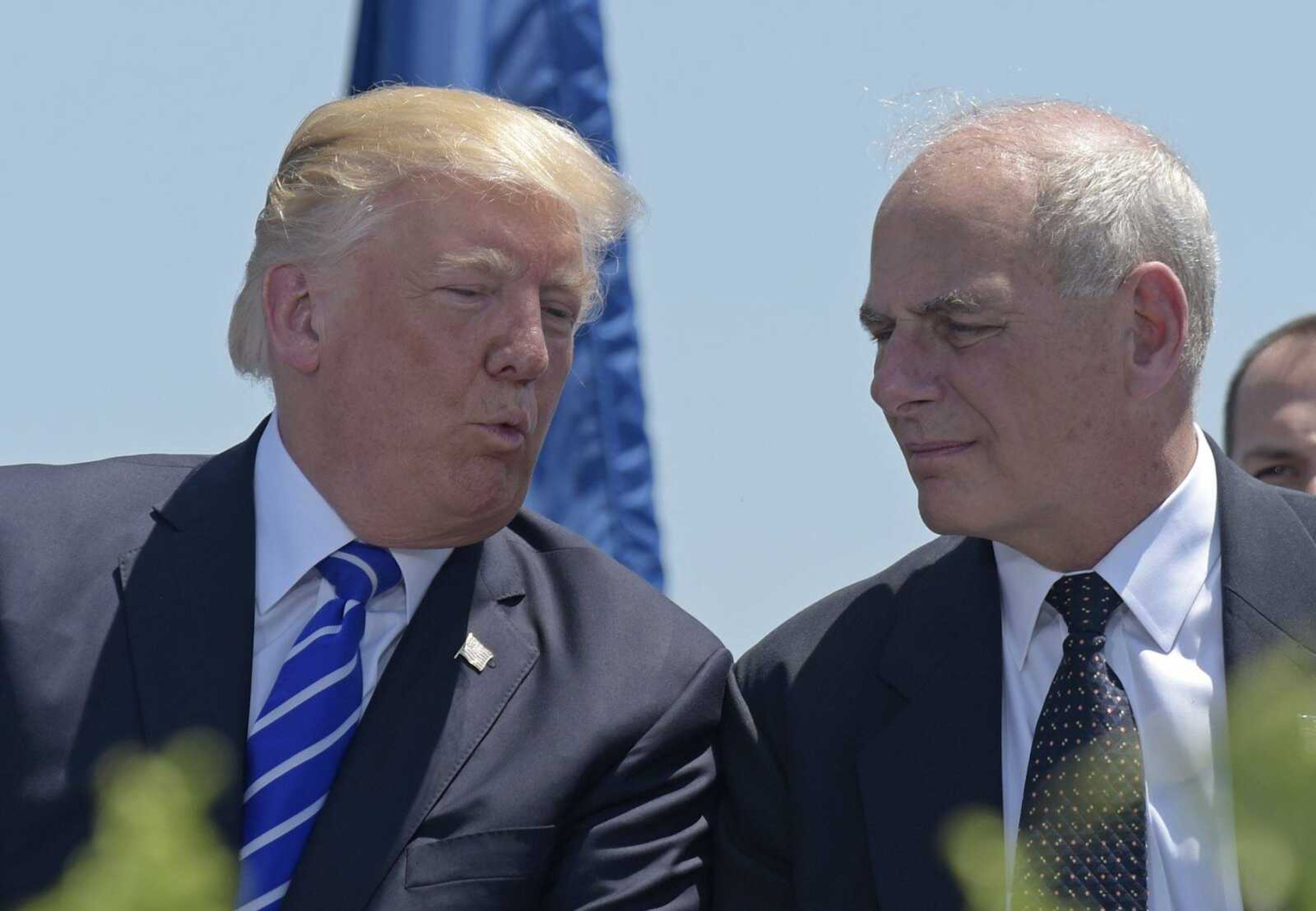 President Donald Trump talks with Homeland Security Secretary John Kelly during commencement May 17 at the U.S. Coast Guard Academy in New London, Connecticut. Trump on Friday named Kelly as his new Chief of Staff, ousting Reince Priebus.