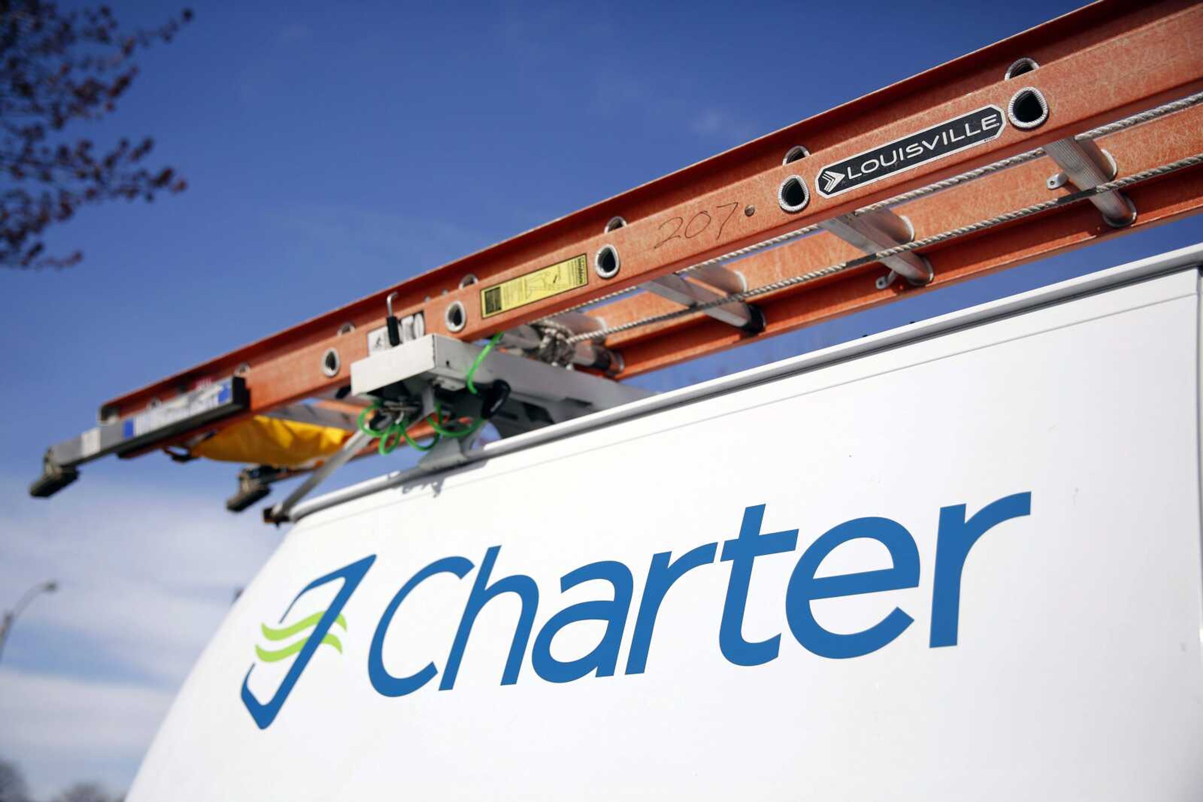 A Charter Communications van is shown in St. Louis. Charter Communications is close to buying Time Warner Cable for about $55 billion, two people familiar with the negotiations said. (Jeff Roberson ~ Associated Press)