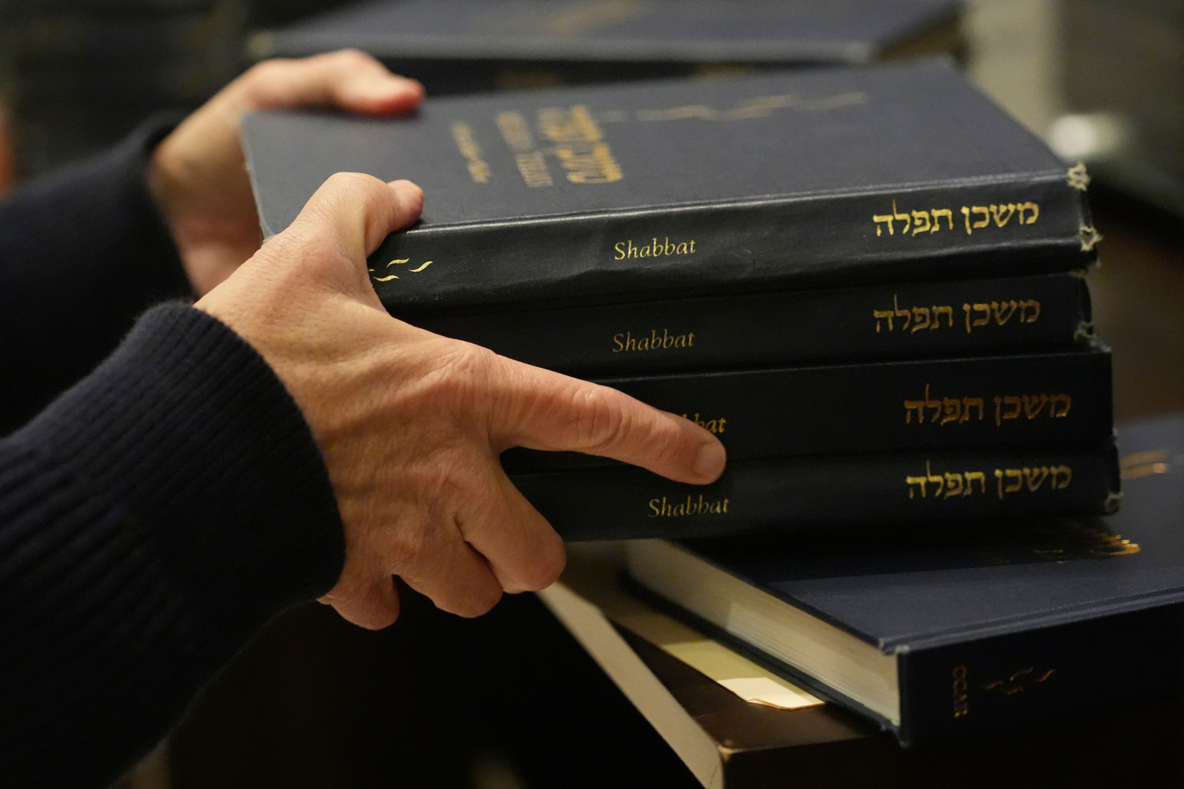 Craig Berko, director of membership at Temple Beth Sholom, prepares to hand out prayer books during a Shabbat service, Friday, Sept. 27, 2024, in Miami Beach, Fla. (AP Photo/Wilfredo Lee)