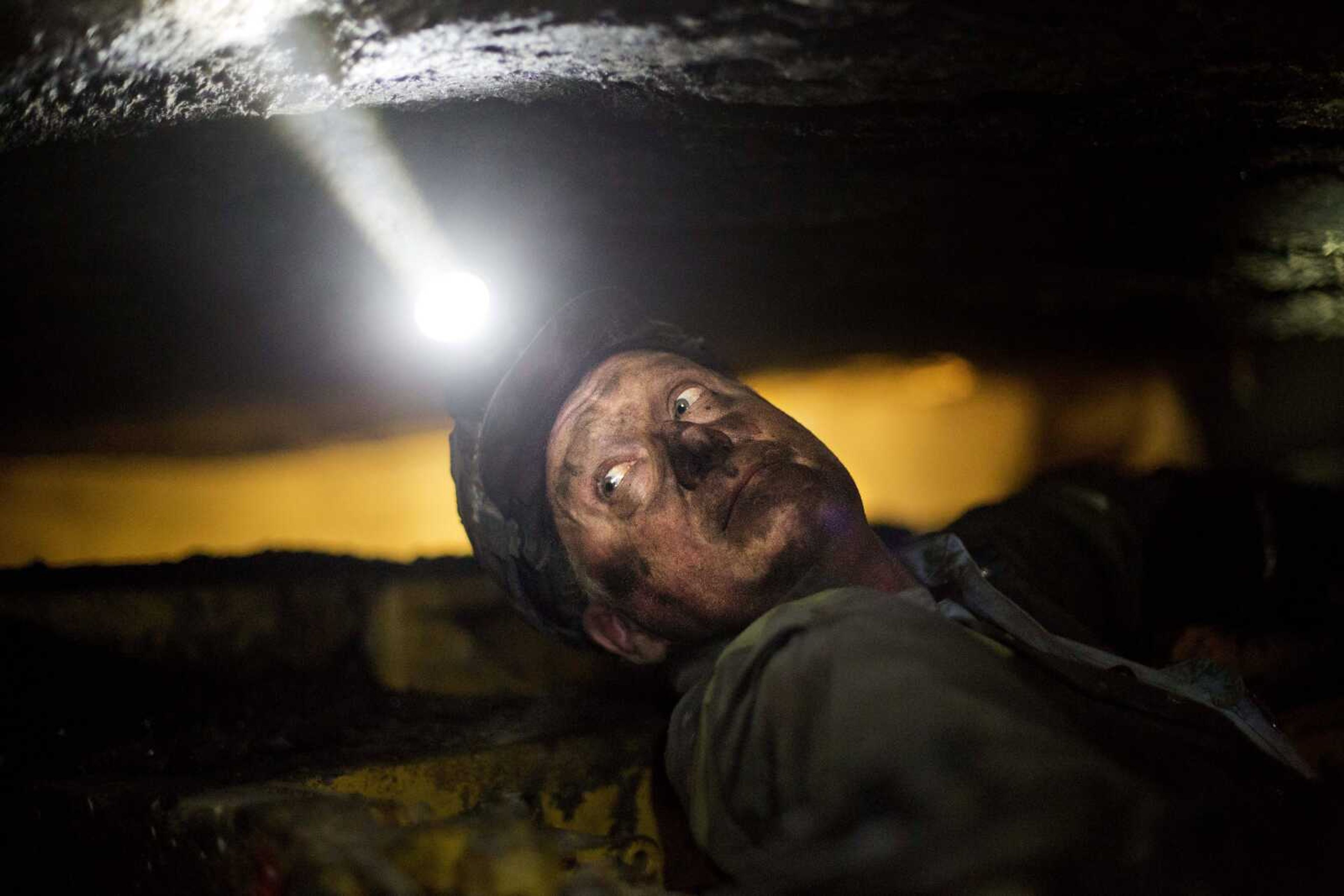 Scott Tiller, a coal miner of 31 years, takes a break while operating a continuous miner machine in a coal mine roughly 40 inches high Tuesday in Welch, West Virginia. (David Goldman ~ Associated Press)