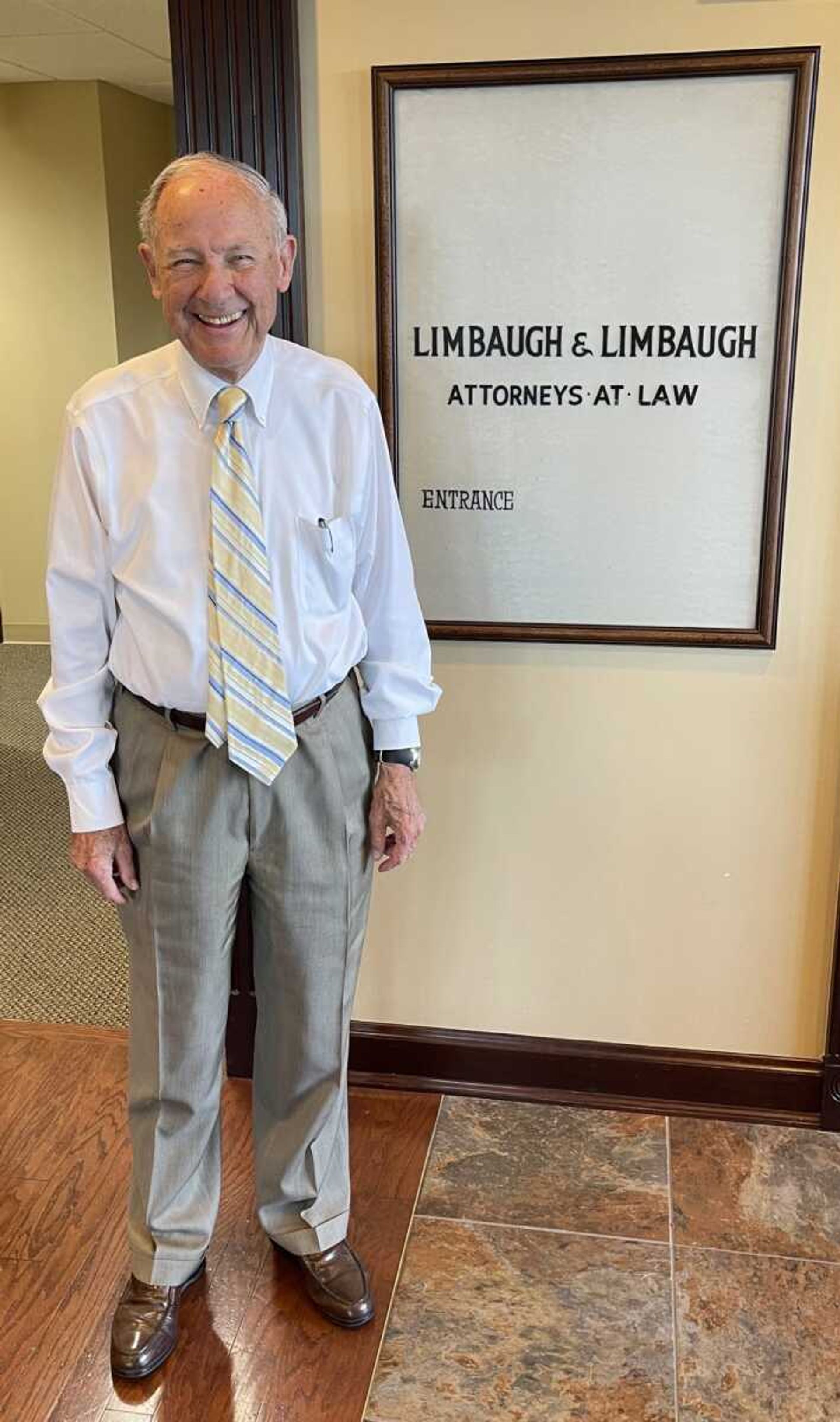 Stephen Limbaugh Sr. stands beside the sign that hung in front of the family law firm when he joined the firm in 1951.