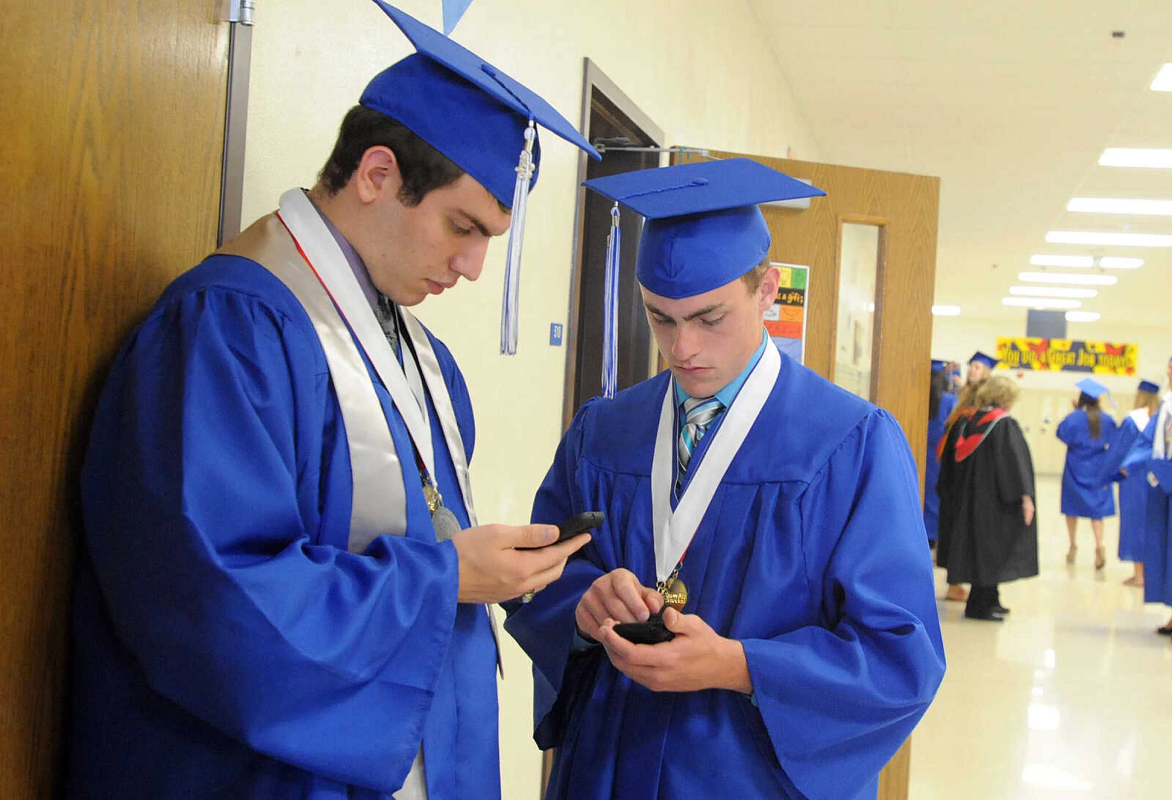 LAURA SIMON ~ lsimon@semissourian.com

Notre Dame Regional High School graduates Ben Hinton, left, and Garrett Watson check their phones, Sunday, May 19, 2013.