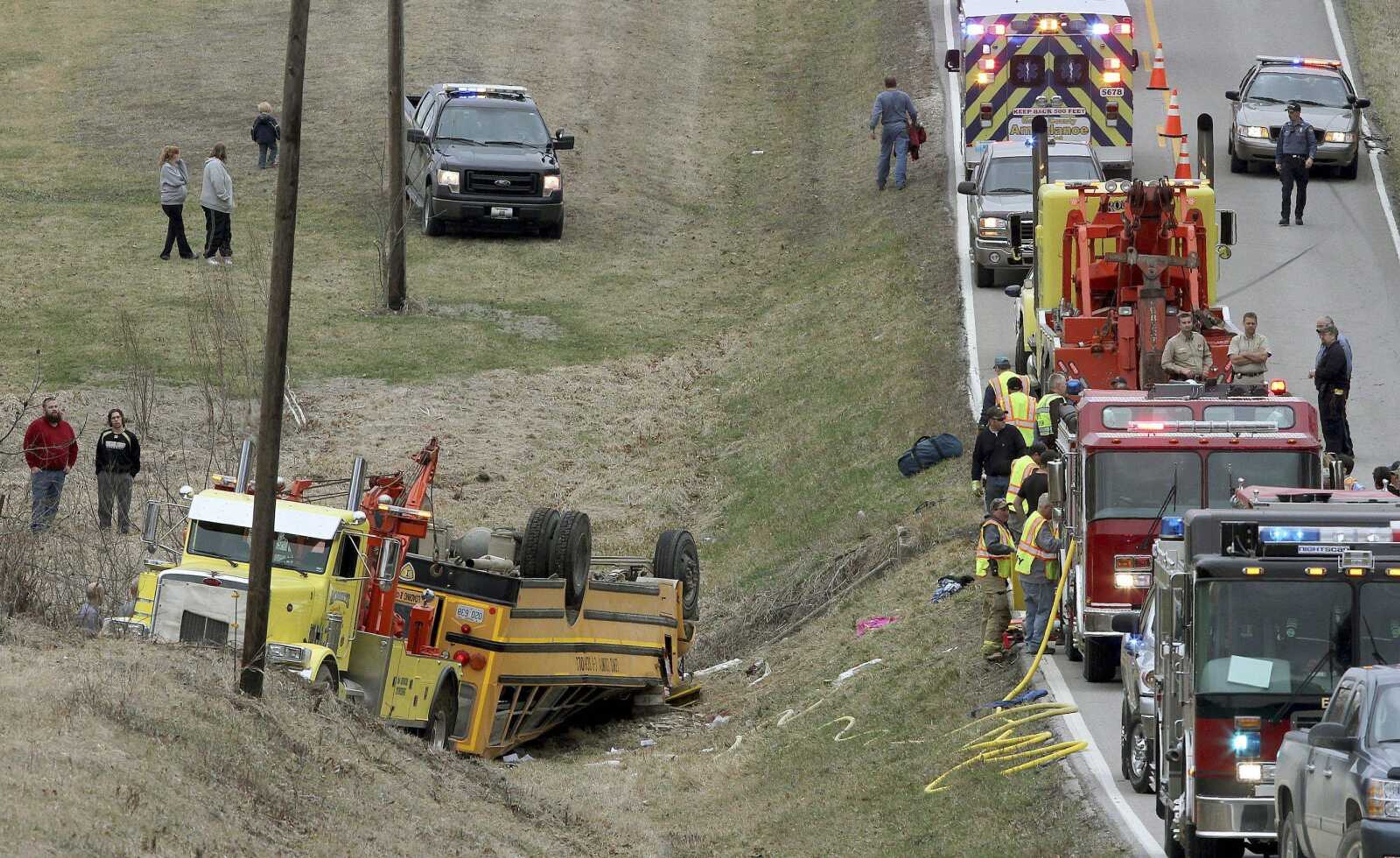 Emergency response personnel work at the scene Tuesday of an overturned school bus near Ewing, Mo., near the Illinois border. (Steve Bohnstedt ~ Quincy Herald Whig)