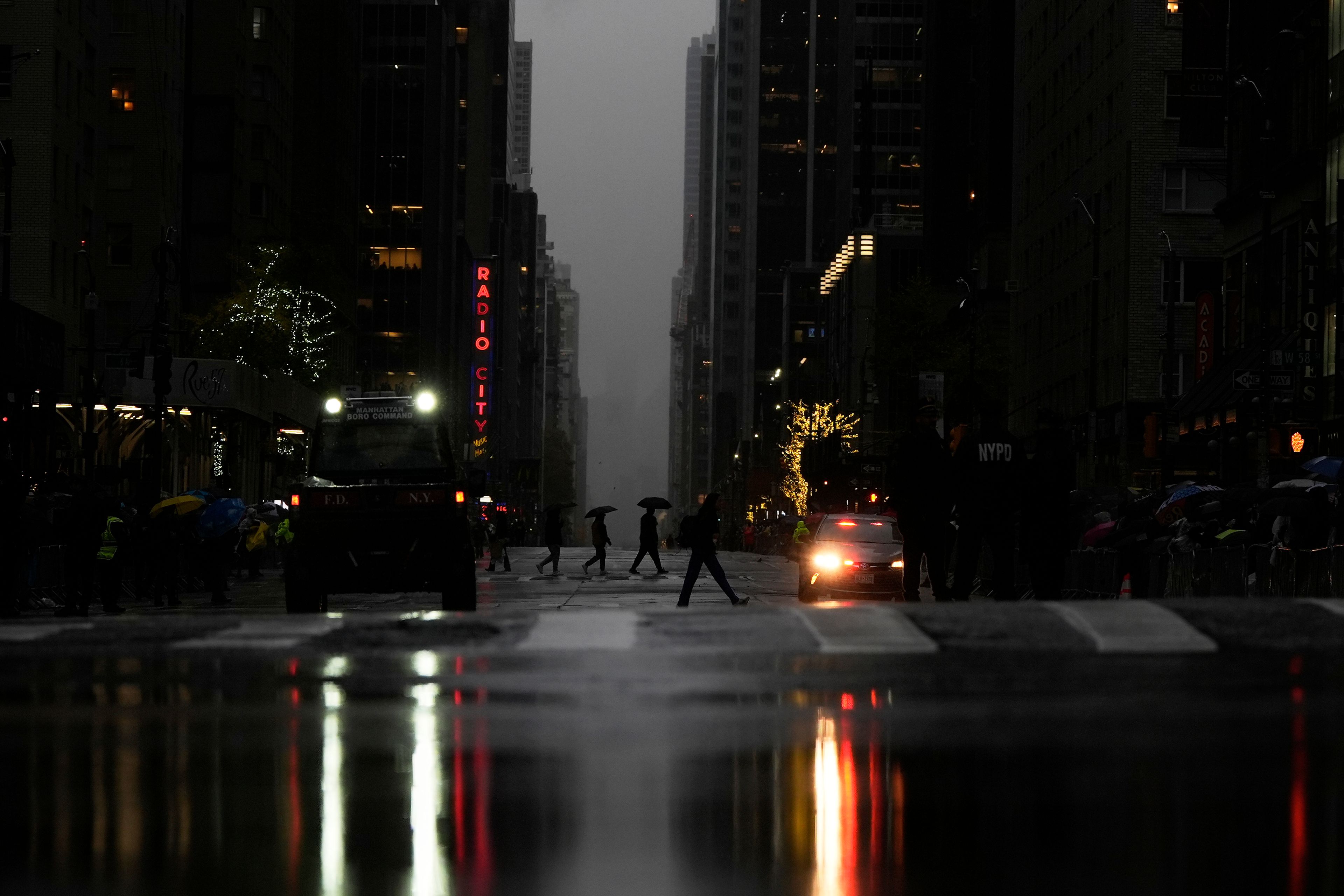 Pedestrians cross Sixth Avenue ahead of the start of the Macy's Thanksgiving Day Parade, Thursday, Nov. 28, 2024, in New York. (AP Photo/Julia Demaree Nikhinson)