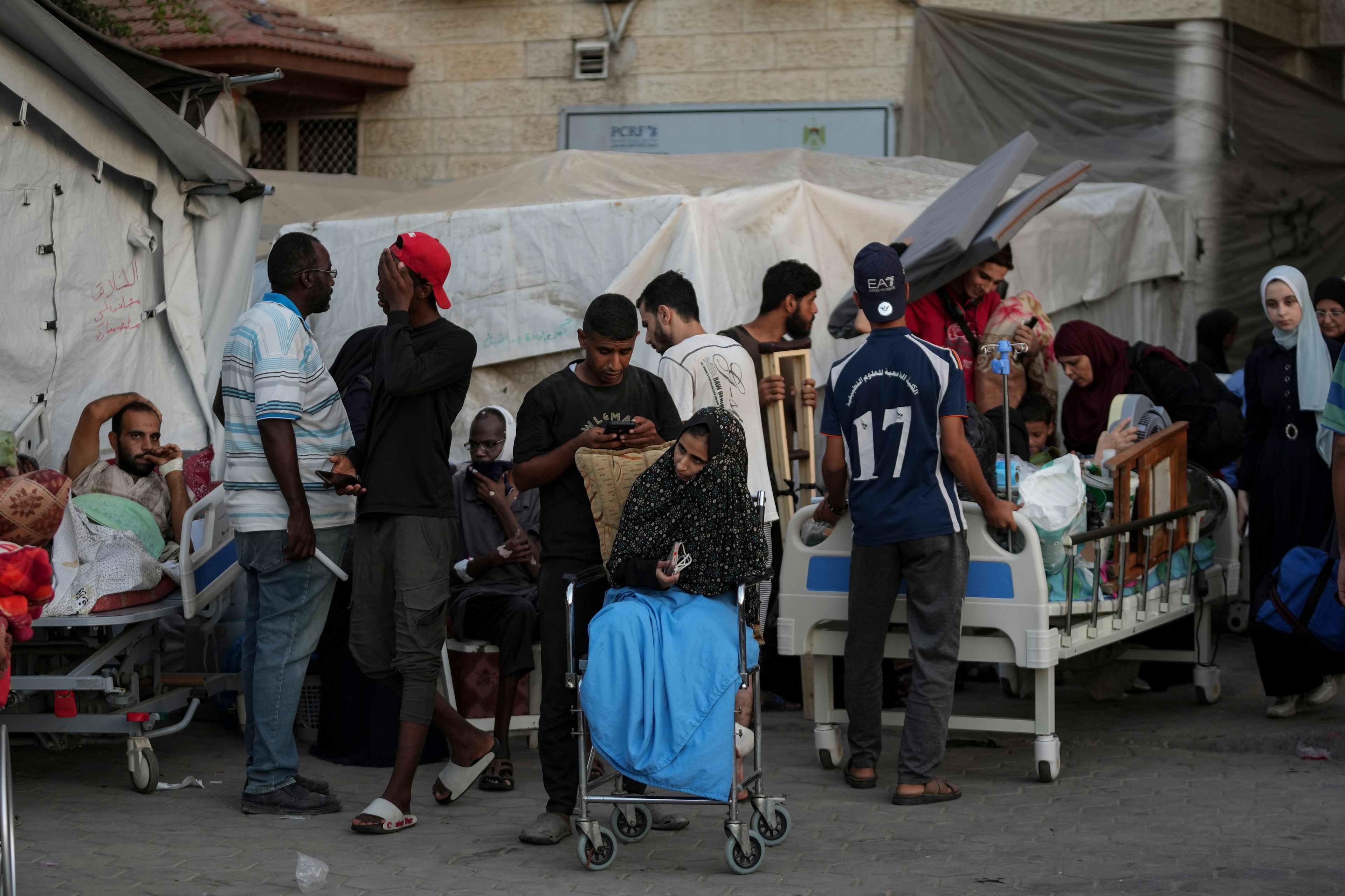 Patients and families move outside the Al-Aqsa Martyrs Hospital in Deir al Balah, Gaza Strip, Sunday, Aug. 25, 2024. (AP Photo/Abdel Kareem Hana)