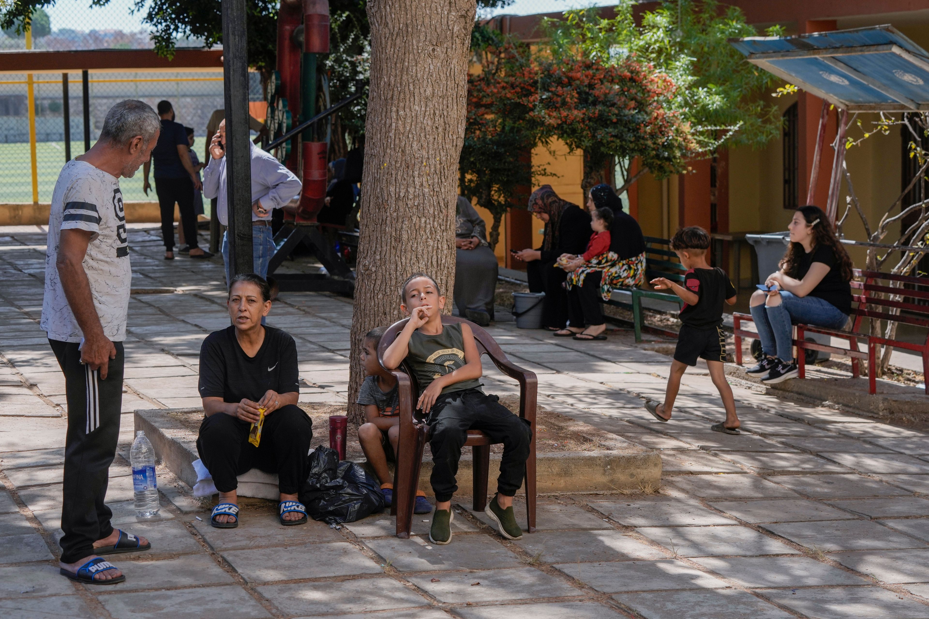 Displaced people sit at a vocational training center run by the U.N. agency for Palestinian refugees, or UNRWA, in the town of Sebline, south of Beirut, Lebanon, Friday, Oct. 4, 2024, after fleeing the Israeli airstrikes in the south. (AP Photo/Bilal Hussein)