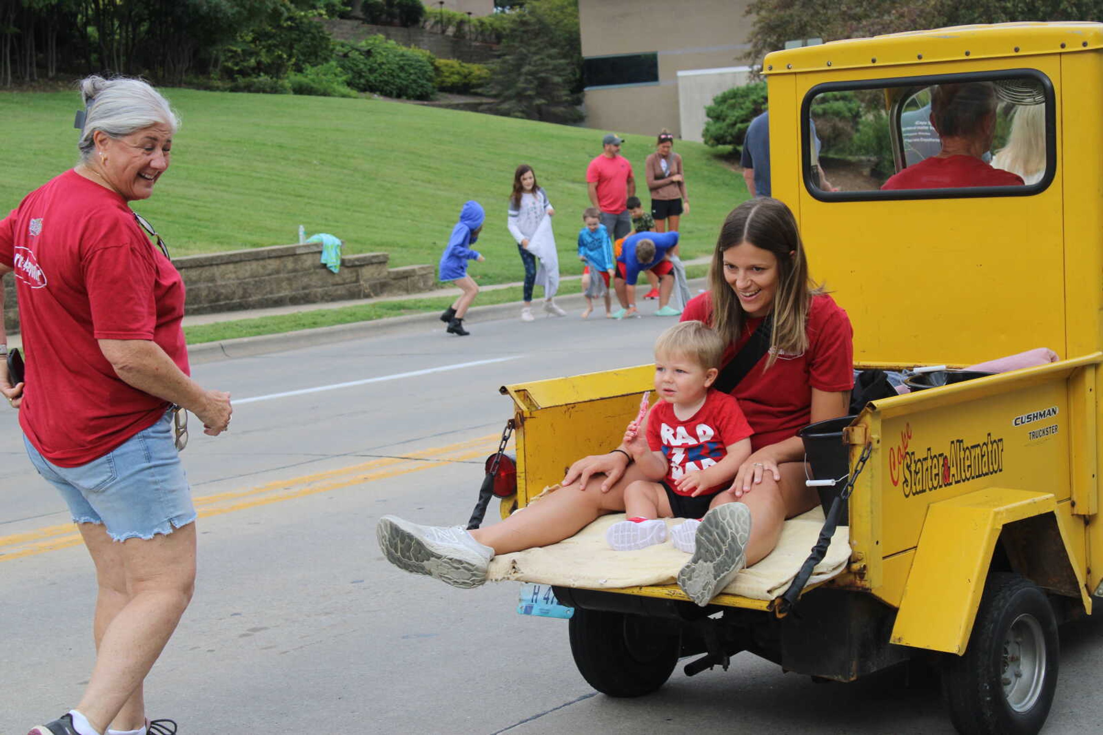 Lindsey Curtis holds her son as they ride and throw candy in the SEMO District Fair parade.