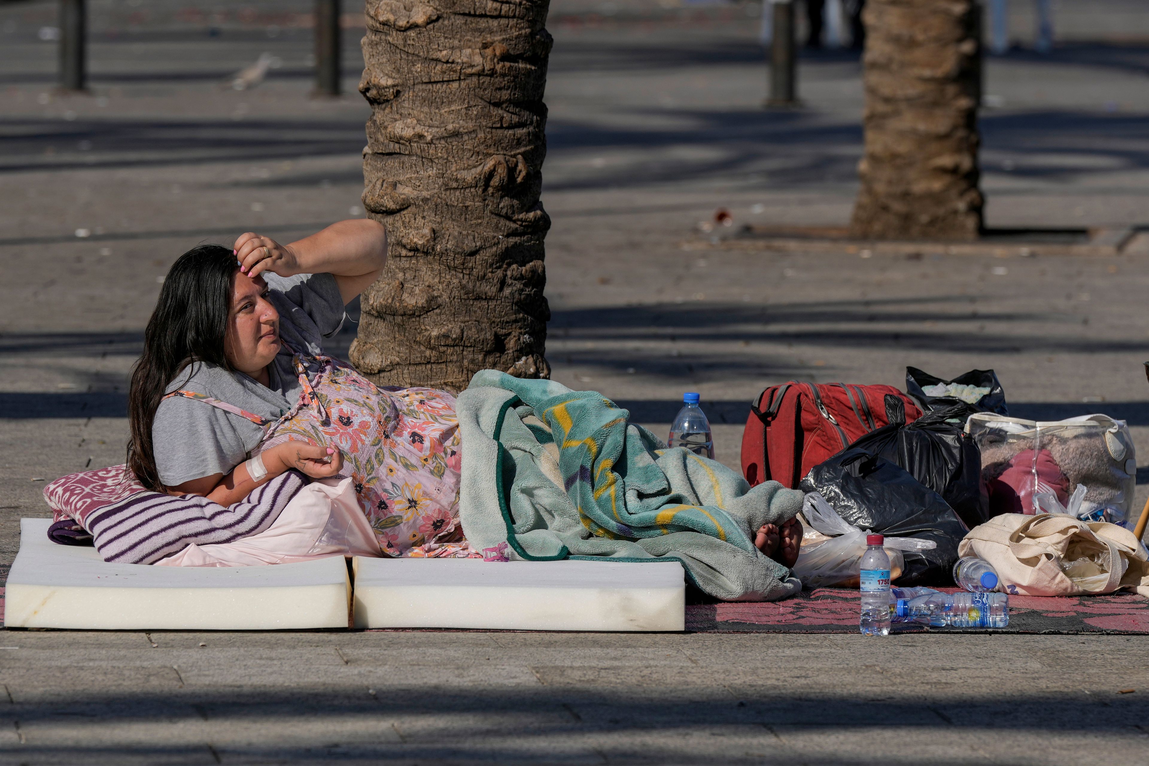 A woman sleeps on Beirut's corniche after fleeing the Israeli airstrikes in the southern suburbs of Dahiyeh, Sunday, Sept. 29, 2024. (AP Photo/Bilal Hussein)