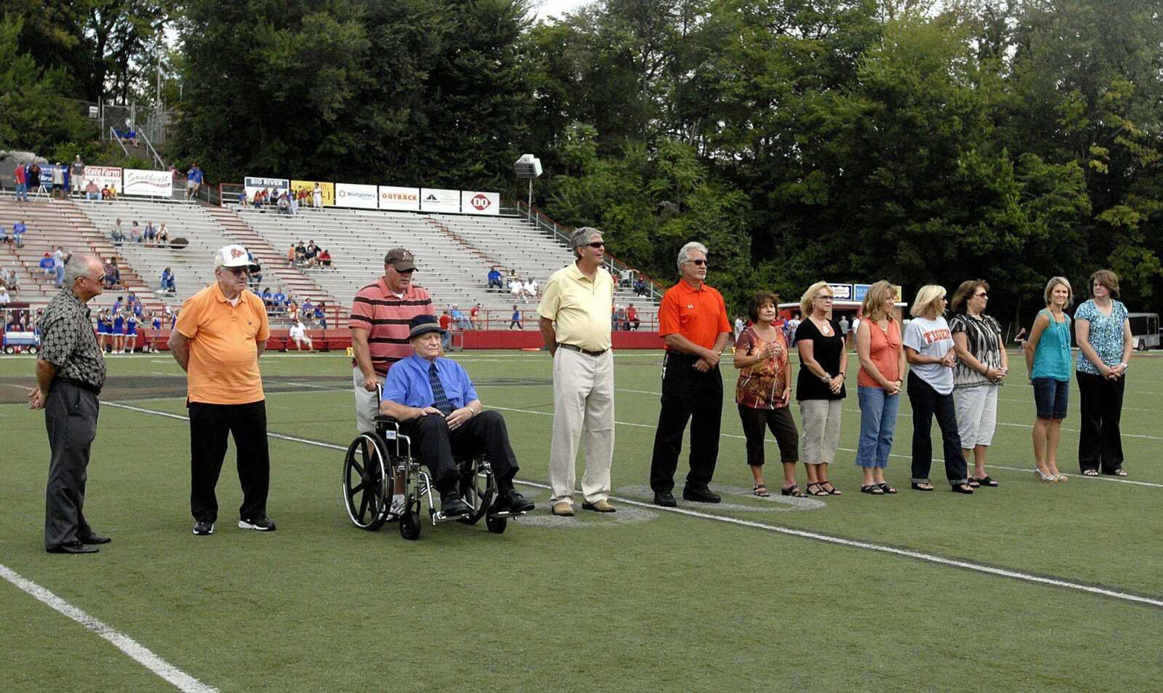 Central athletic hall of fame inductees, from left, Wayne Boswell, Weldon Hager, coach Bob Goodwin(in wheelchair), Walt Grebing, Kim Godwin, representing Jack Burris are his five daughters &#8212; Debbie Suhre, Laura Younghouse, Kim Kasten, Linda Stiefferman, and Diane Bickings &#8212; Nichole Thiele-Clippard and Sherri Boeller Shirrell are honored during halftime of Saturday's game at Houck Stadium. (Laura Simon)