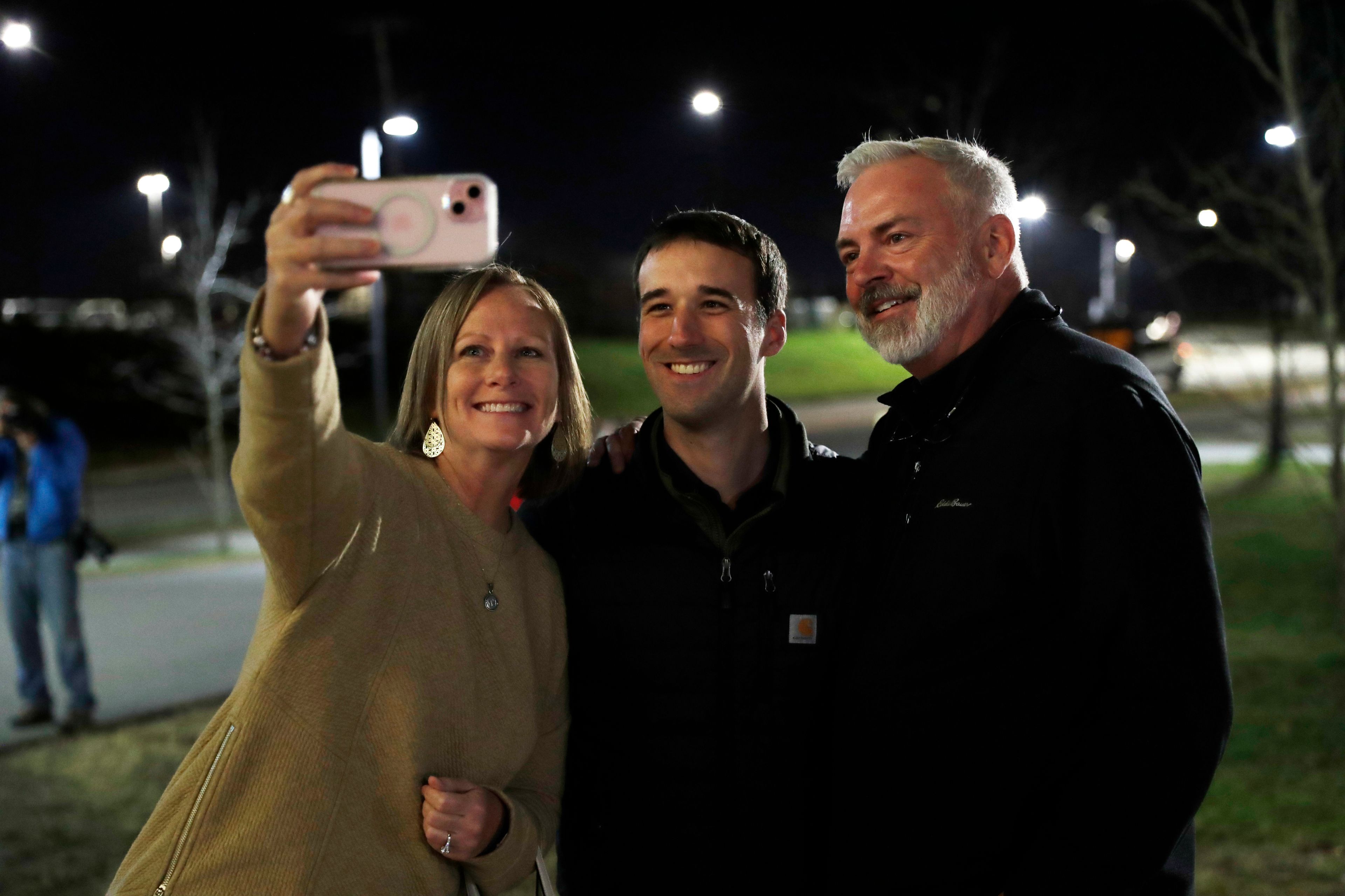 Republican congressional candidate Austin Theriault, center, poses for a photo with supporters Tuesday, Nov. 5, 2024 outside the Cross Insurance Center in Bangor, Maine. (AP Photo/Joel Page)