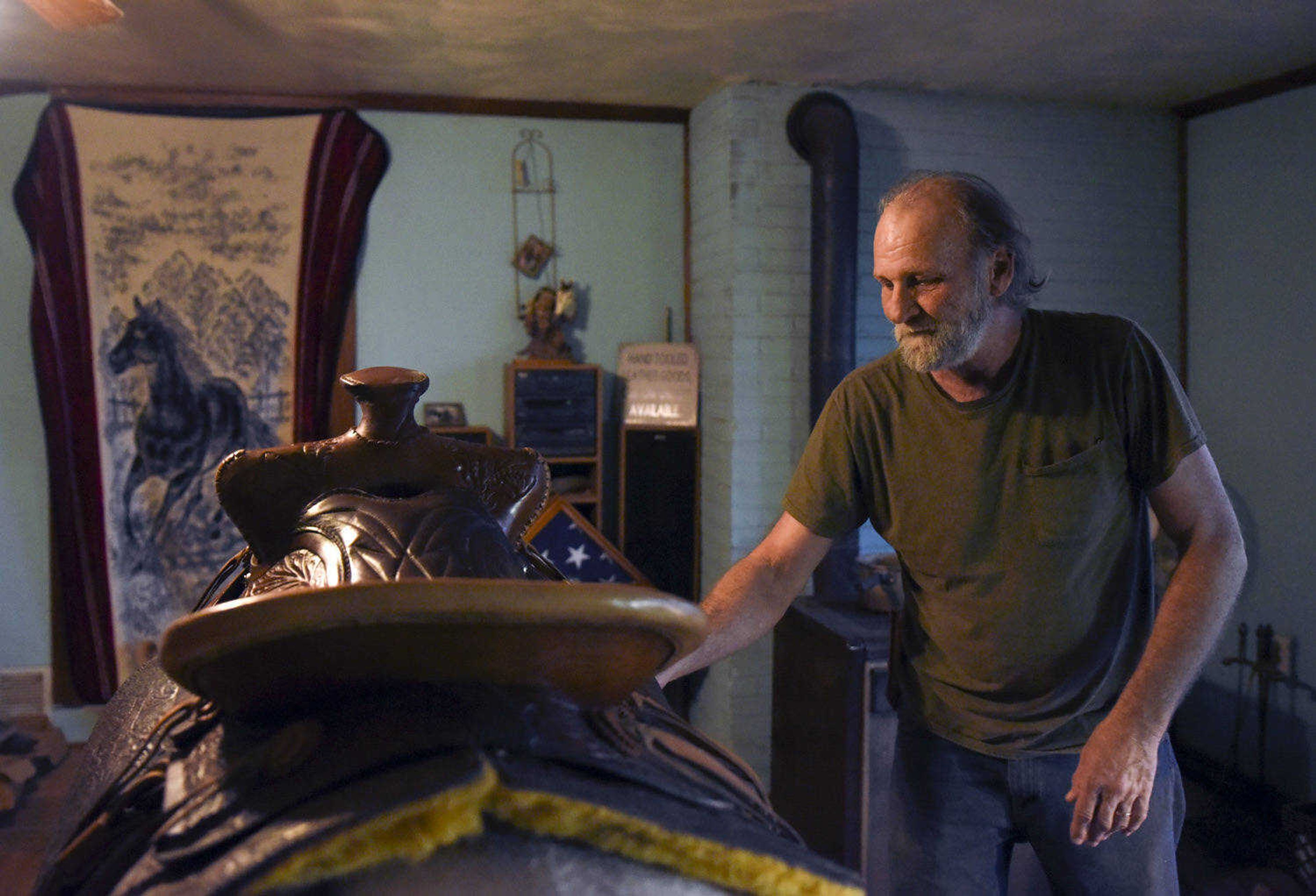 John Hedge shows off a handmade saddle in his home on Tuesday, March 27, 2018, in Advance.