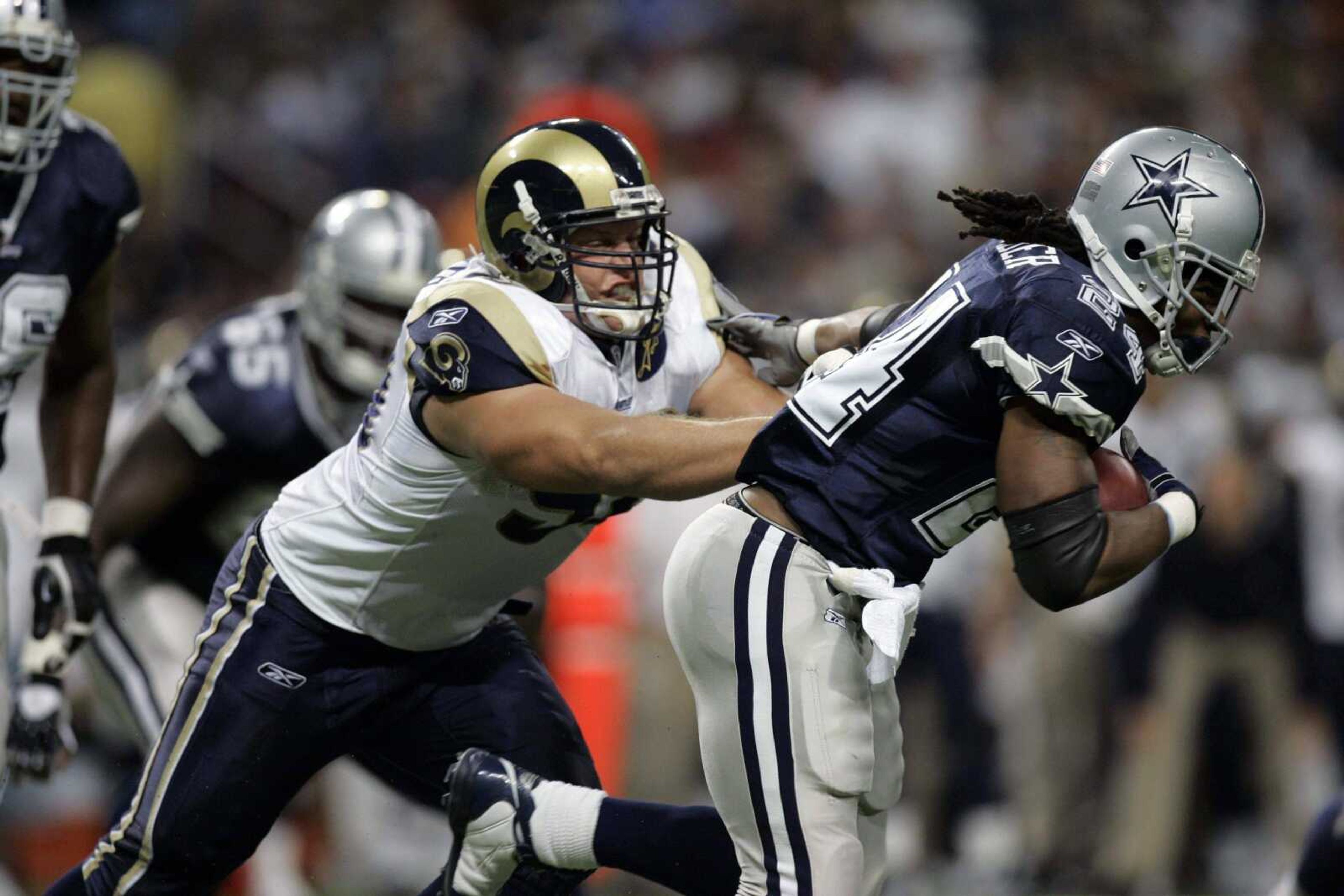 JEFF ROBERSON ~ Associated Press<br>Rams defensive lineman Adam Carriker tries to slow down Cowboys running back Marion Barber during their game earlier this season in St. Louis.