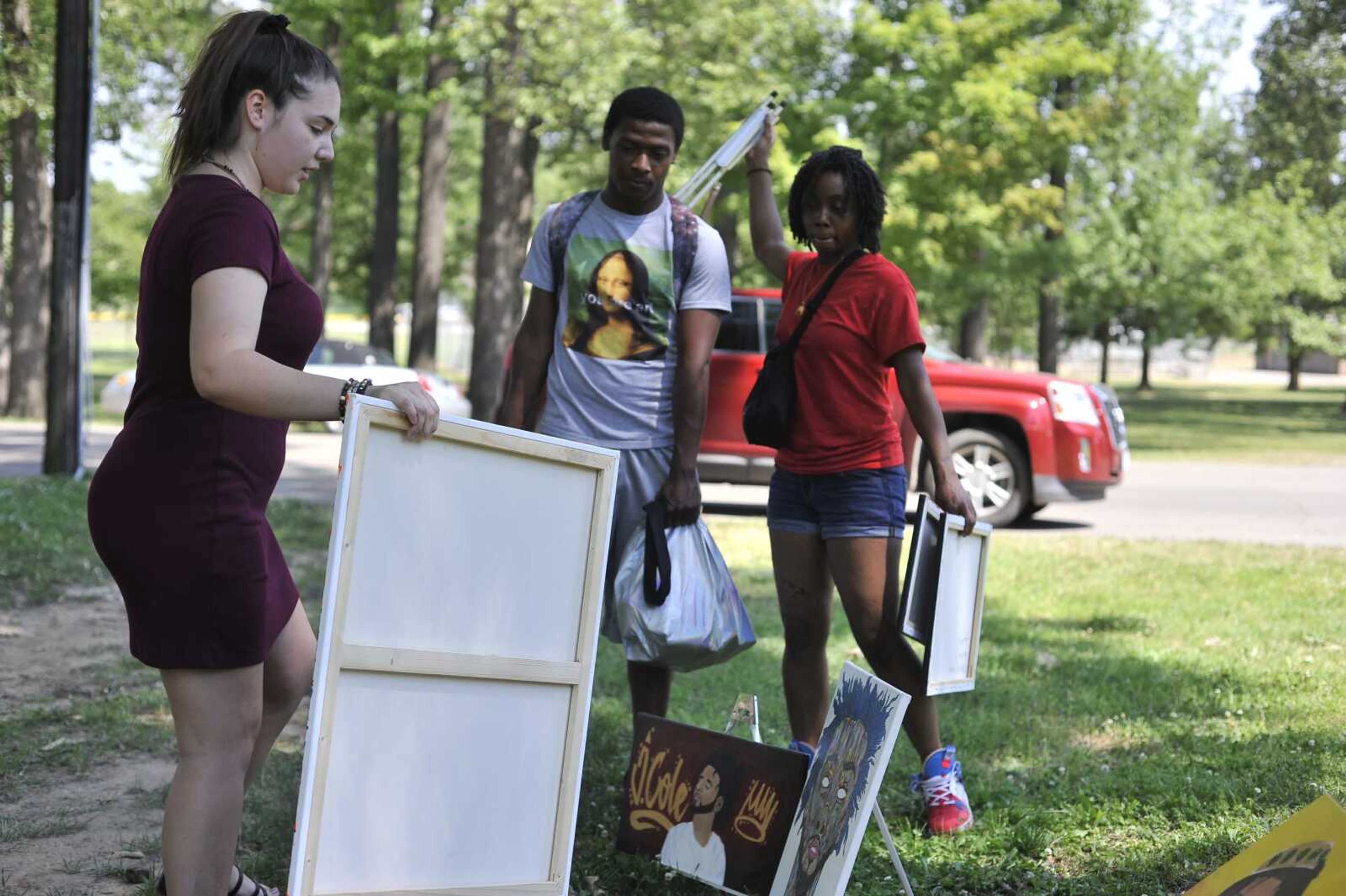 Macy Brady, left, Simuel Smith and Keihanna Smith set up artwork at a Juneteenth celebration Friday, June 19, 2020, at Arena Park in Cape Girardeau.