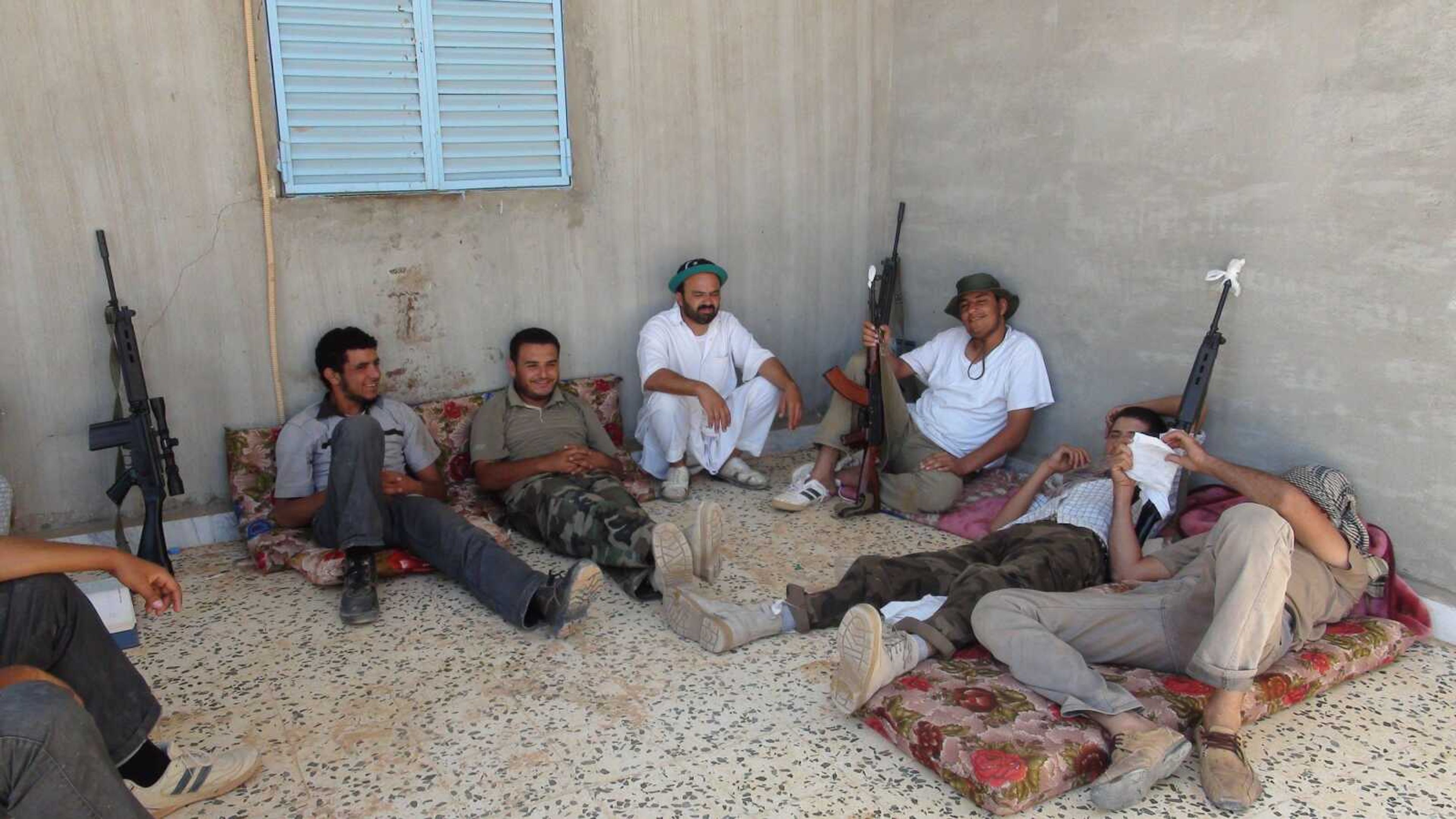 Rebel fighters from the Tripoli Brigade relax Monday at their base close to the front line near the town of Tiji, western Libya. The rebel fighters of the Tripoli Brigade have a single purpose - to be among the first to enter the Libyan capital and kick out Moammar Gadhafi and his loyalists, aided by their intimate knowledge of the city. (Balint Szlanko ~ Associated Press)