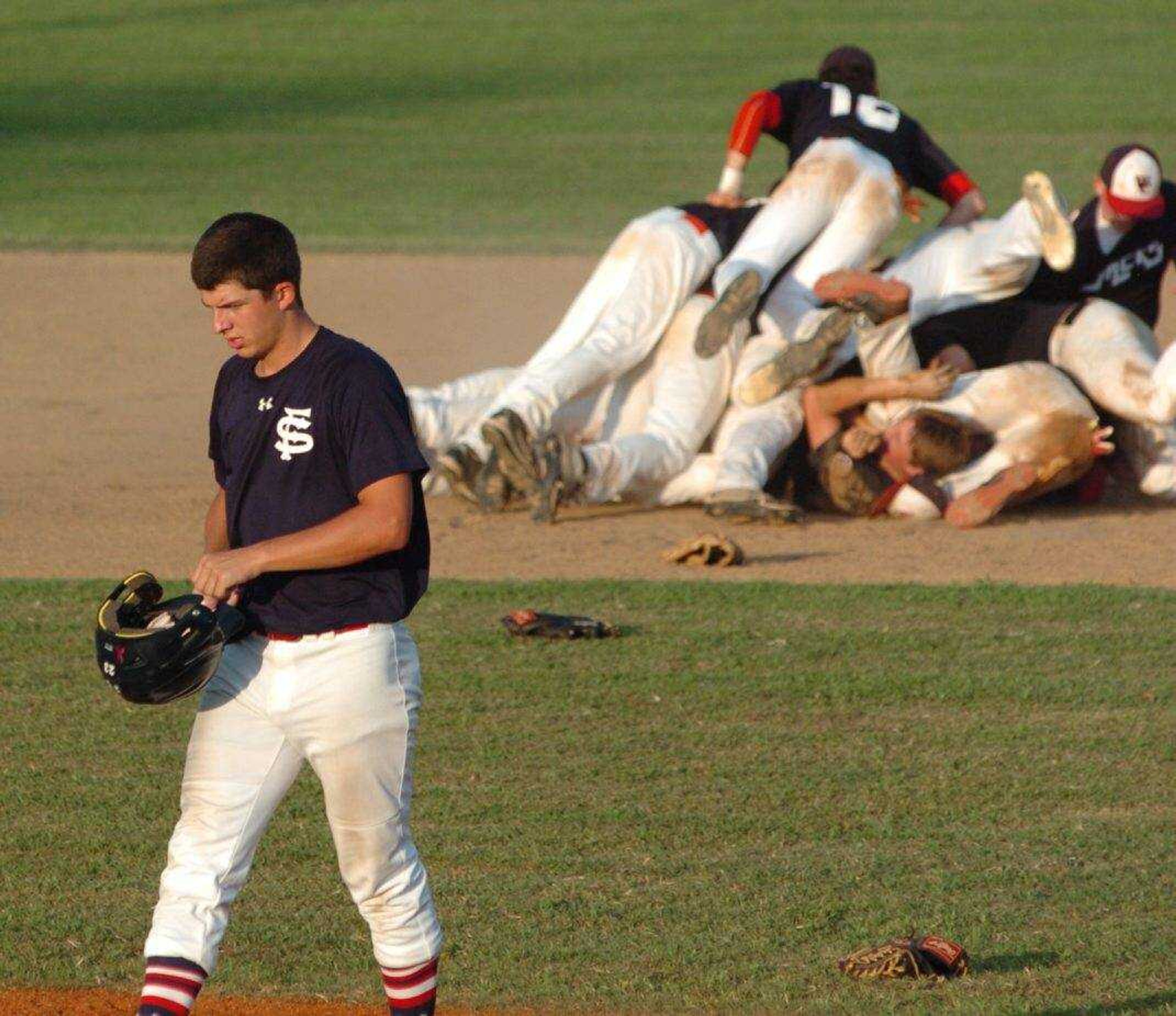 The Fighting Squirrels' Chase Urhahn walks off the field while the Lumberjacks celebrate their 6-3 win over Charleston in the championship game of the Senior Babe Ruth state tournament Saturday at Hillhouse Park in Charleston. (Brent Shipman ~ Sikeston Standard Democrat)