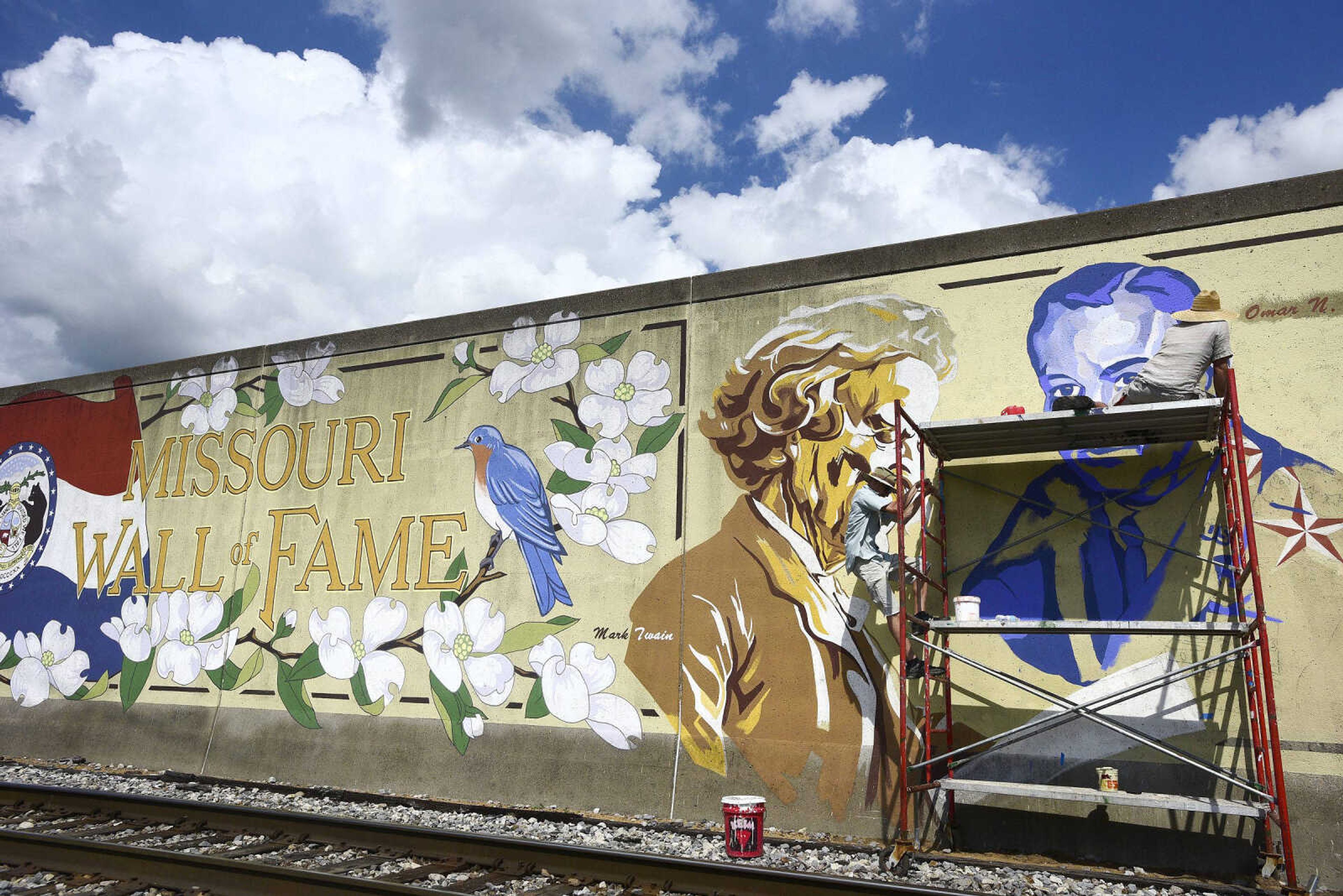 Jess Wells, left, and Craig Thomas work on a mural of the late Gen. Seth McKee Thursday.