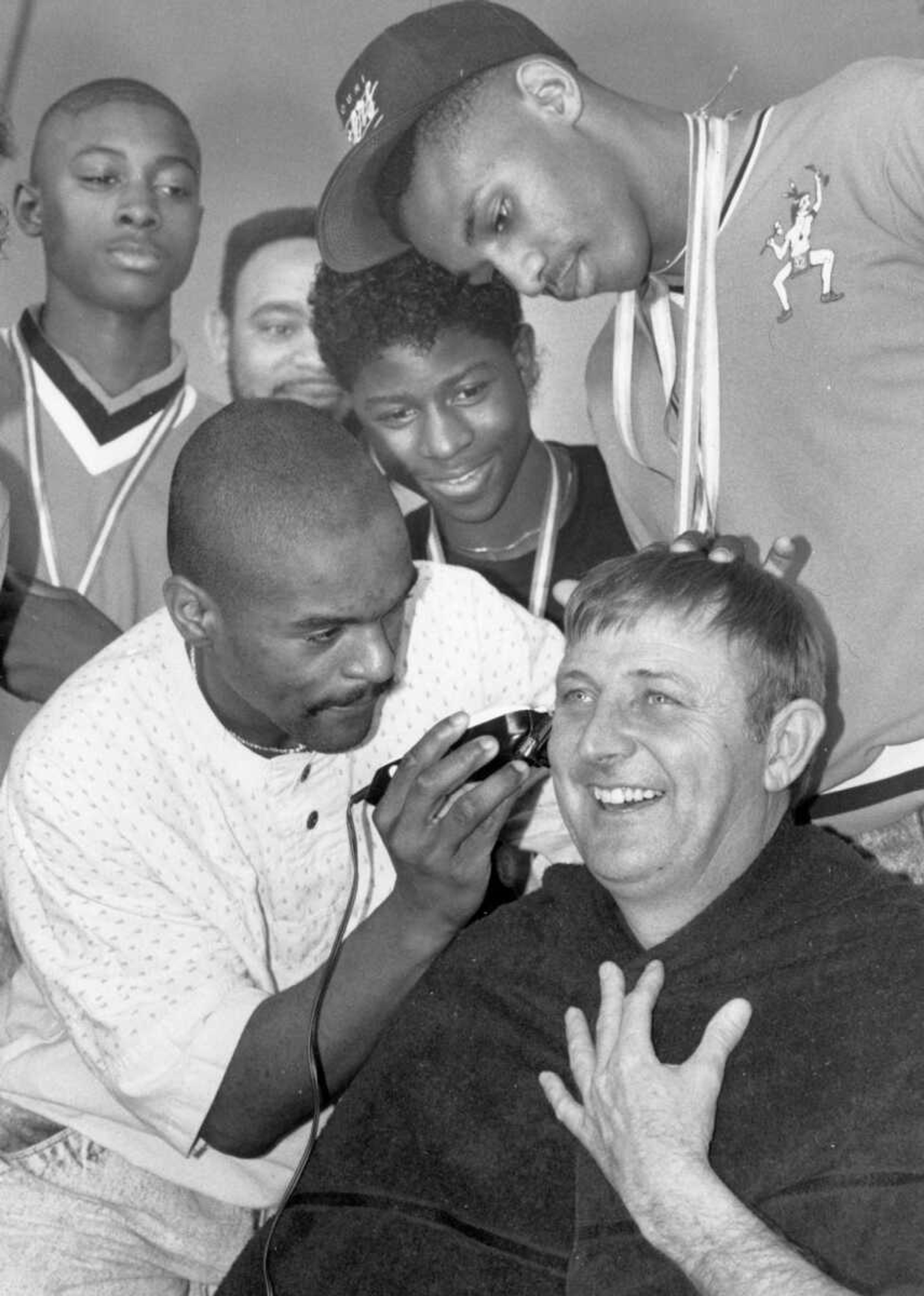 Published March 14, 1990.
Coach Ron Cookson of Scott County Central High School got some extra attention from members of his Braves basketball team. Cookson allowed Roger Banks, left, and Marcus Timmons, above, to reshape his hair in celebration of the team winning the Missouri Class 1A basketball championship for the sixth consecutive year. The victory also marked Cookson's 500th career win. (Fred Lynch ~ Southeast Missourian archive photo)