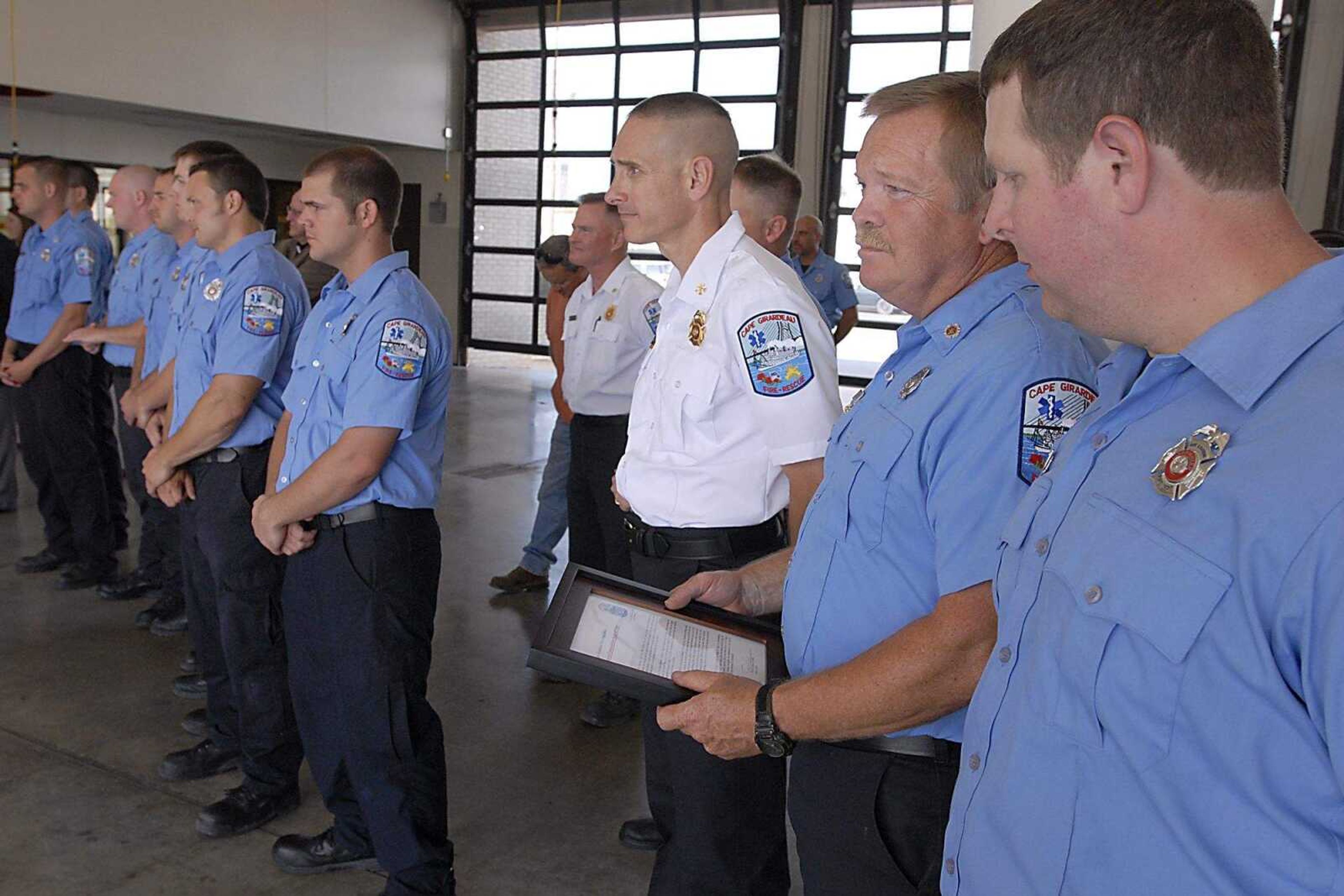 KIT DOYLE ~ kdoyle@semissourian.com
Derrick Carlton, right, glanced a Harry Schumer's Medal of Valor plaque as the ceremony closed Friday, June 6, 2008, at the Cape Girardeau Fire Station No. 1.