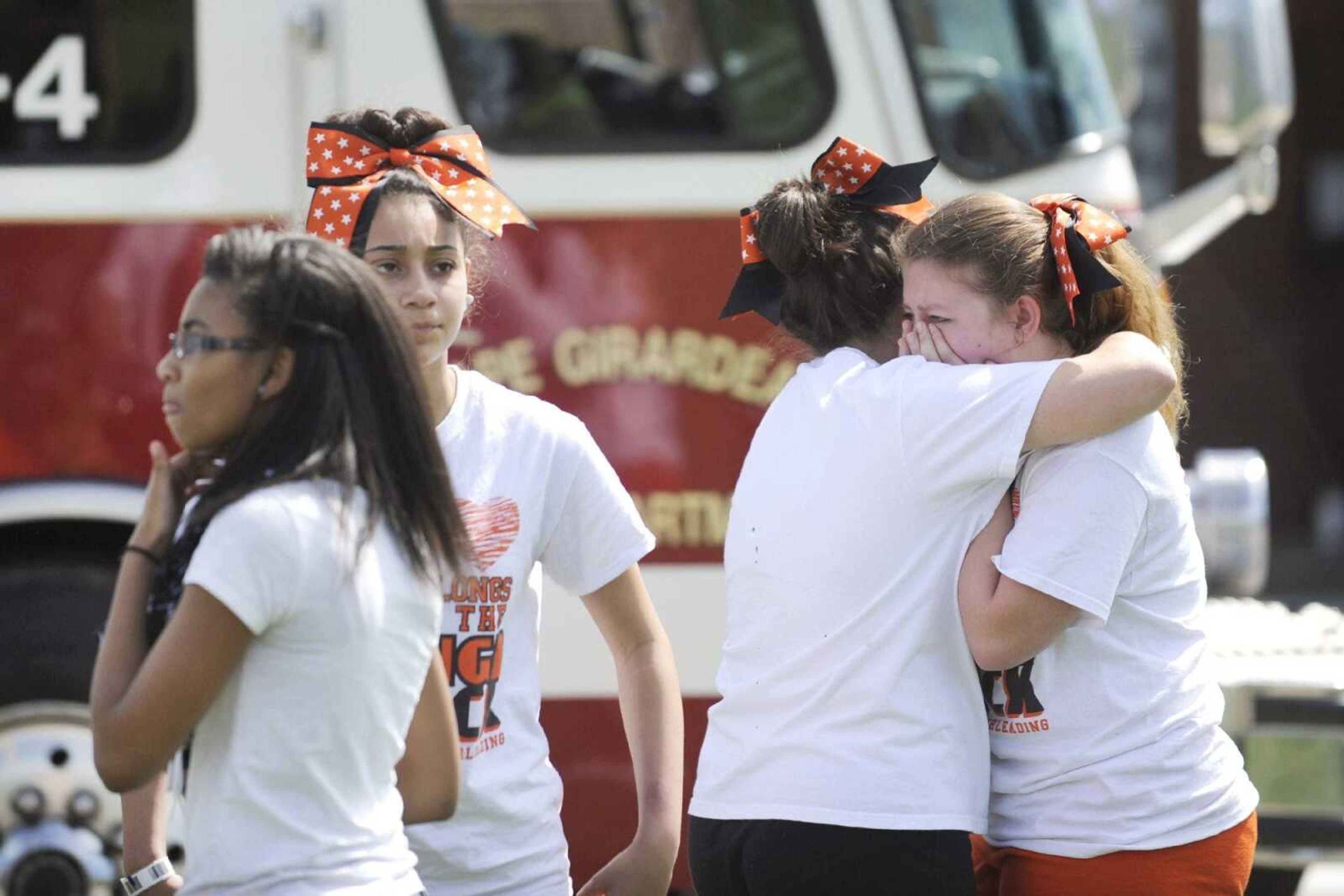 Members of the Cape Central Junior High School cheerleading squad console each other after a teammate was struck by a vehicle on Independence Street outside the school Tuesday. (Glenn Landberg)