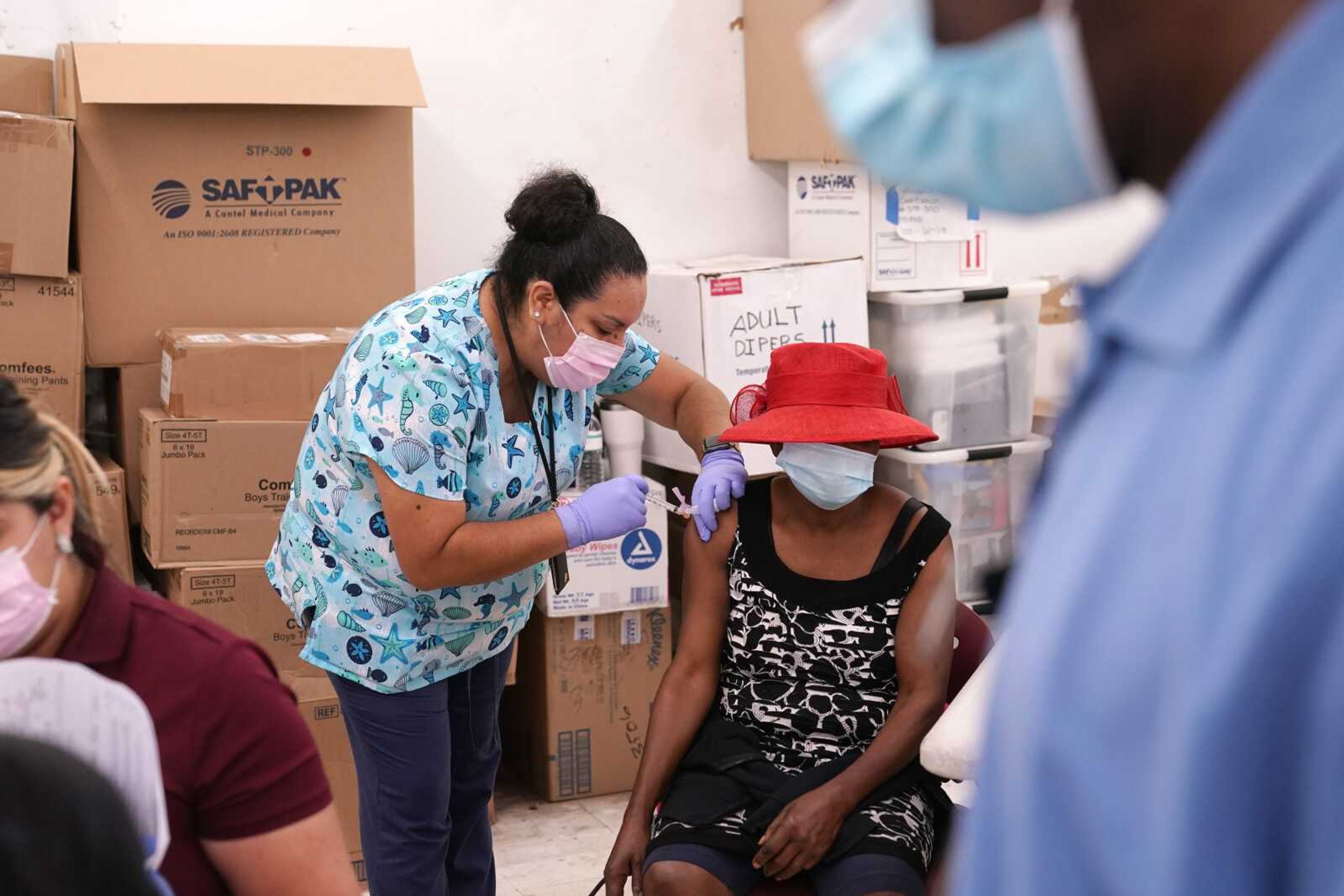 Registered nurse Ashleigh Velasco, left, administers the Johnson & Johnson COVID-19 vaccine to Rosemene Lordeus, right, at a clinic held by Healthcare Network on April 10 in Immokalee, Florida.