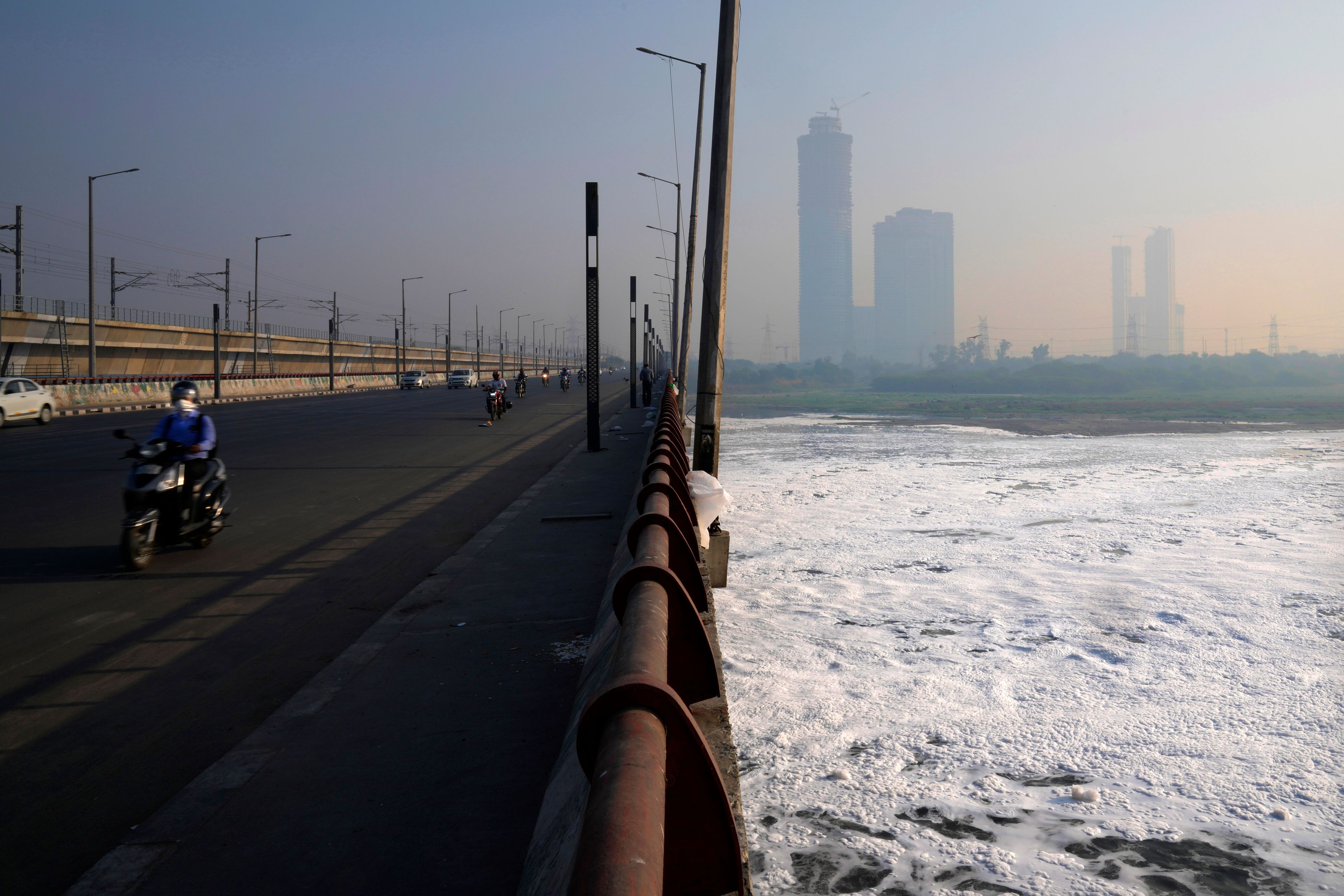 A commuter rides in the early morning smog on a bridge over Yamuna river covered in pollutants the day after the Hindu festival Diwali, in New Delhi, India, Friday, Nov. 1, 2024. (AP Photo/Manish Swarup)