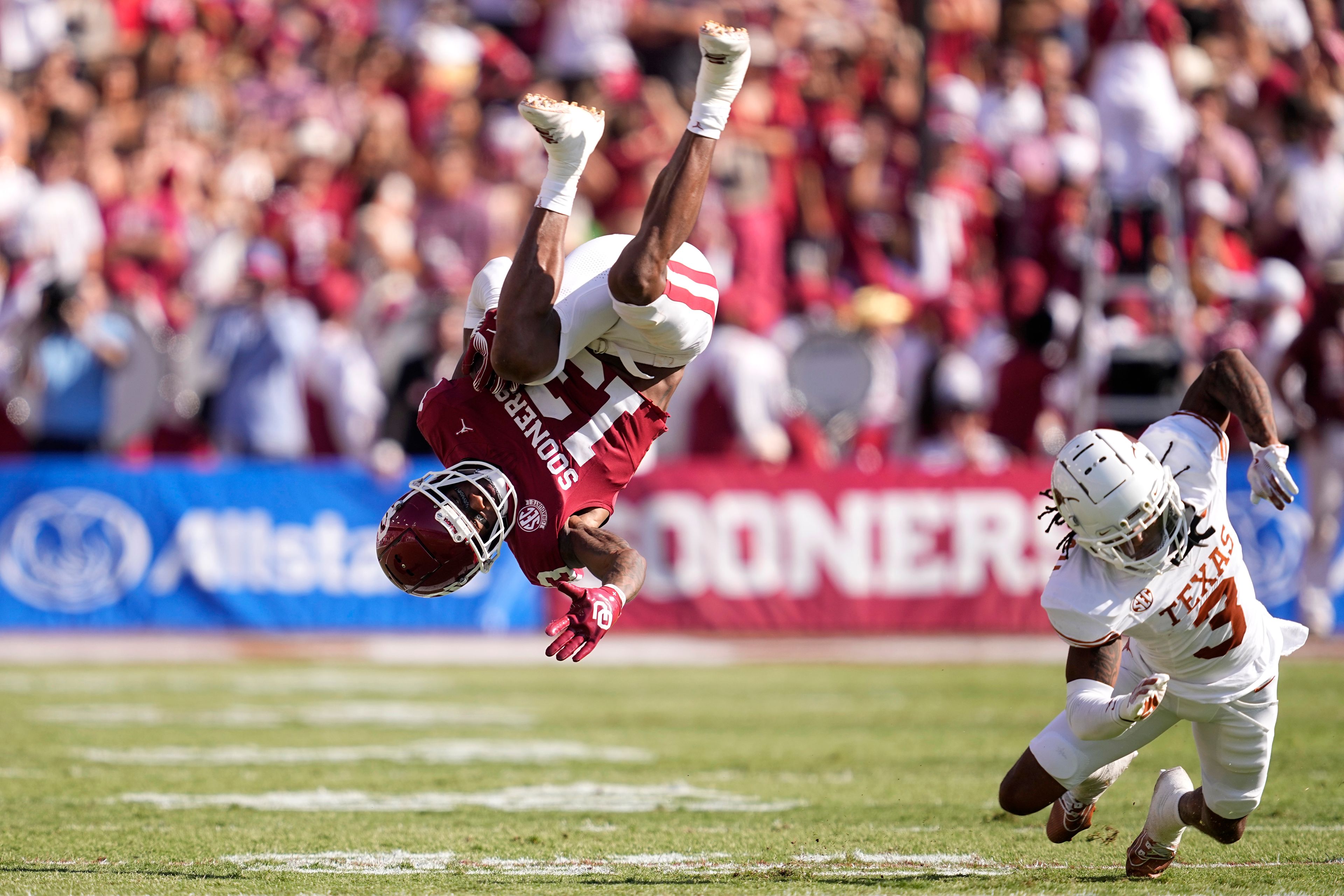 Oklahoma wide receiver J.J. Hester (13) is upended after catching a pass by Texas defensive back Jaylon Guilbeau (3) in the first half of an NCAA college football game in Dallas, Saturday, Oct. 12, 2024. (AP Photo/Tony Gutierrez)